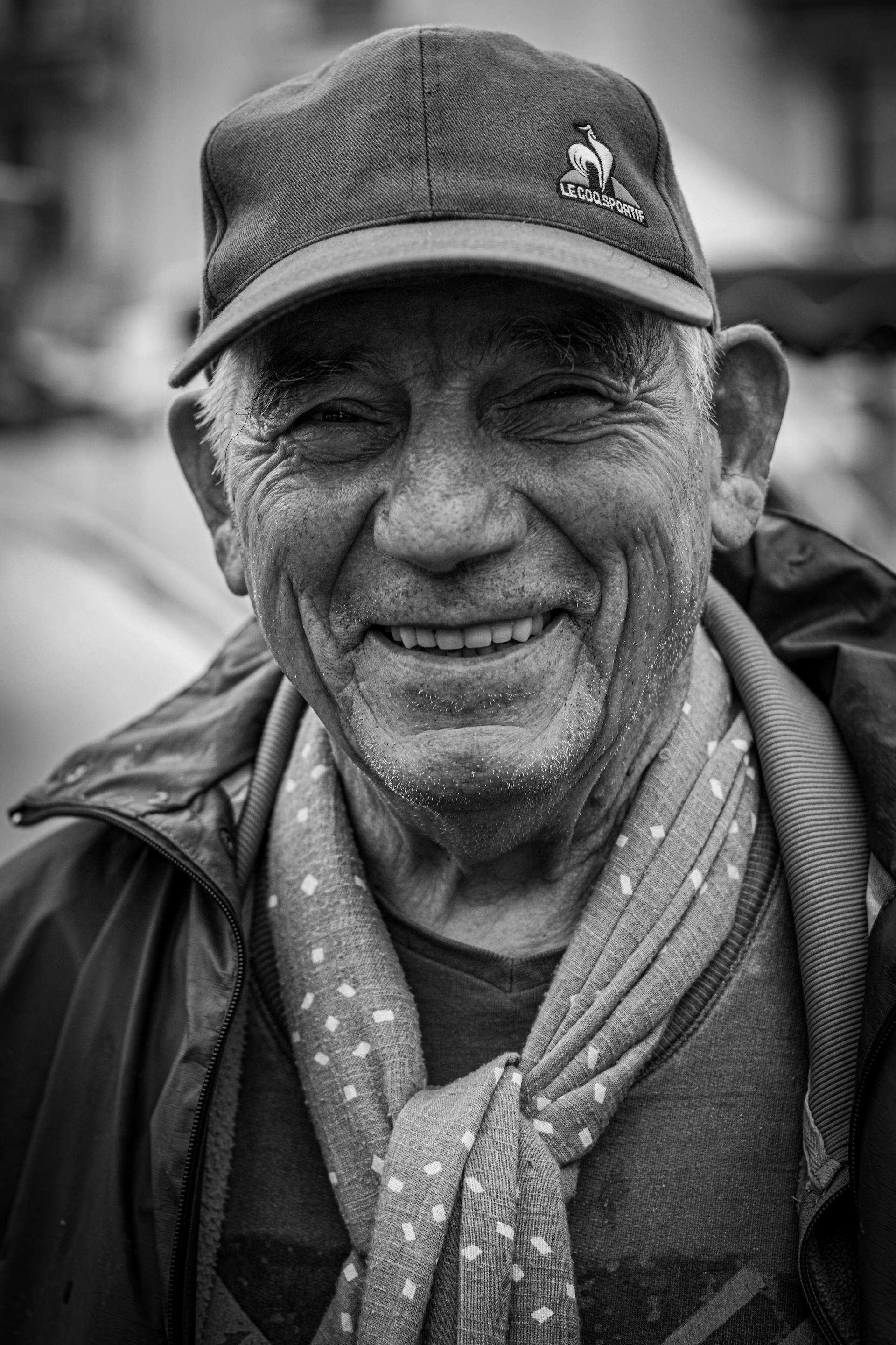 Ein Graustufenfoto eines lächelnden Mannes, der eine Mütze trägt | Quelle: Pexels