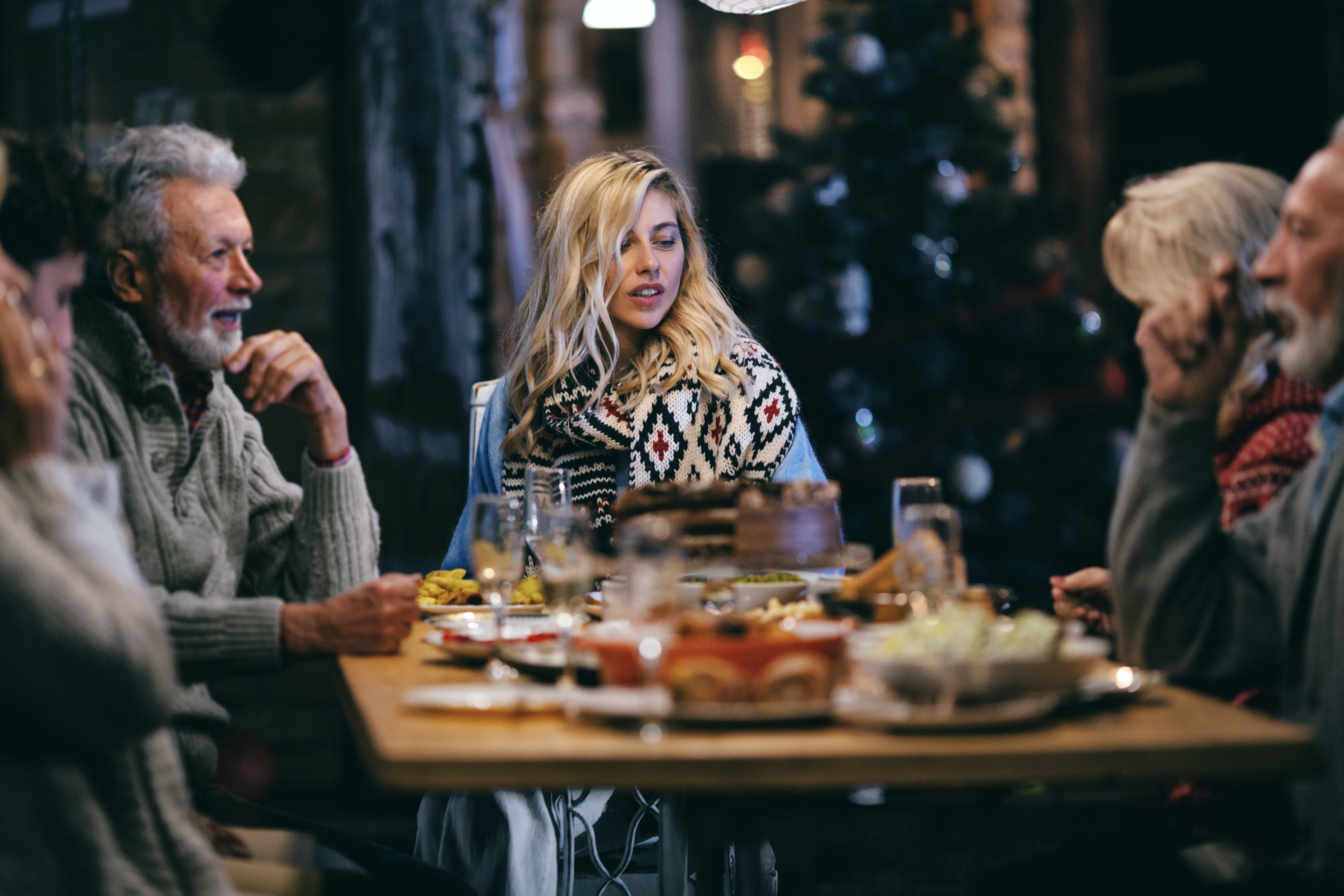 Familienmitglieder unterhalten sich beim Abendessen | Quelle: Getty Images