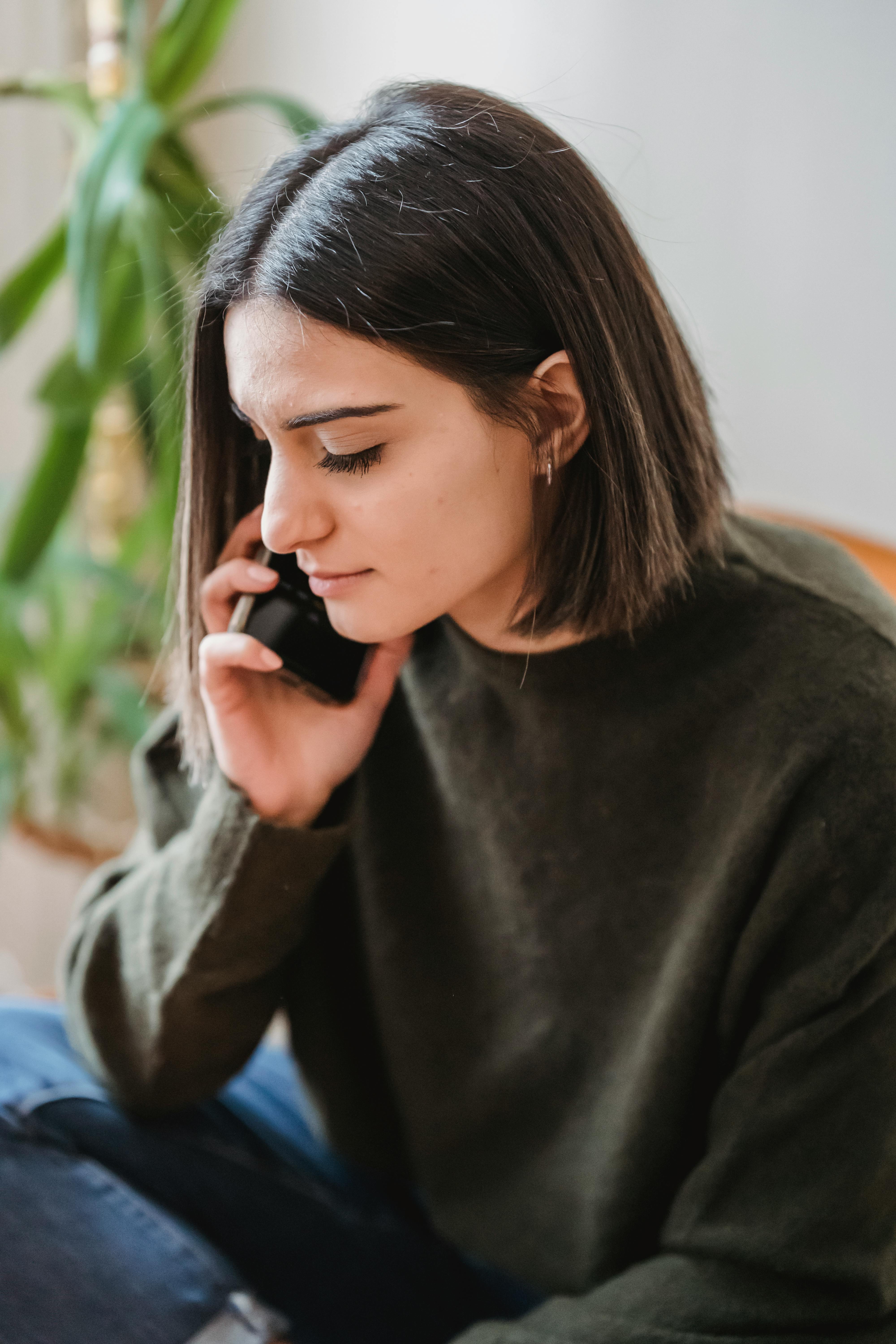 Eine traurige Frau am Telefon | Quelle: Pexels