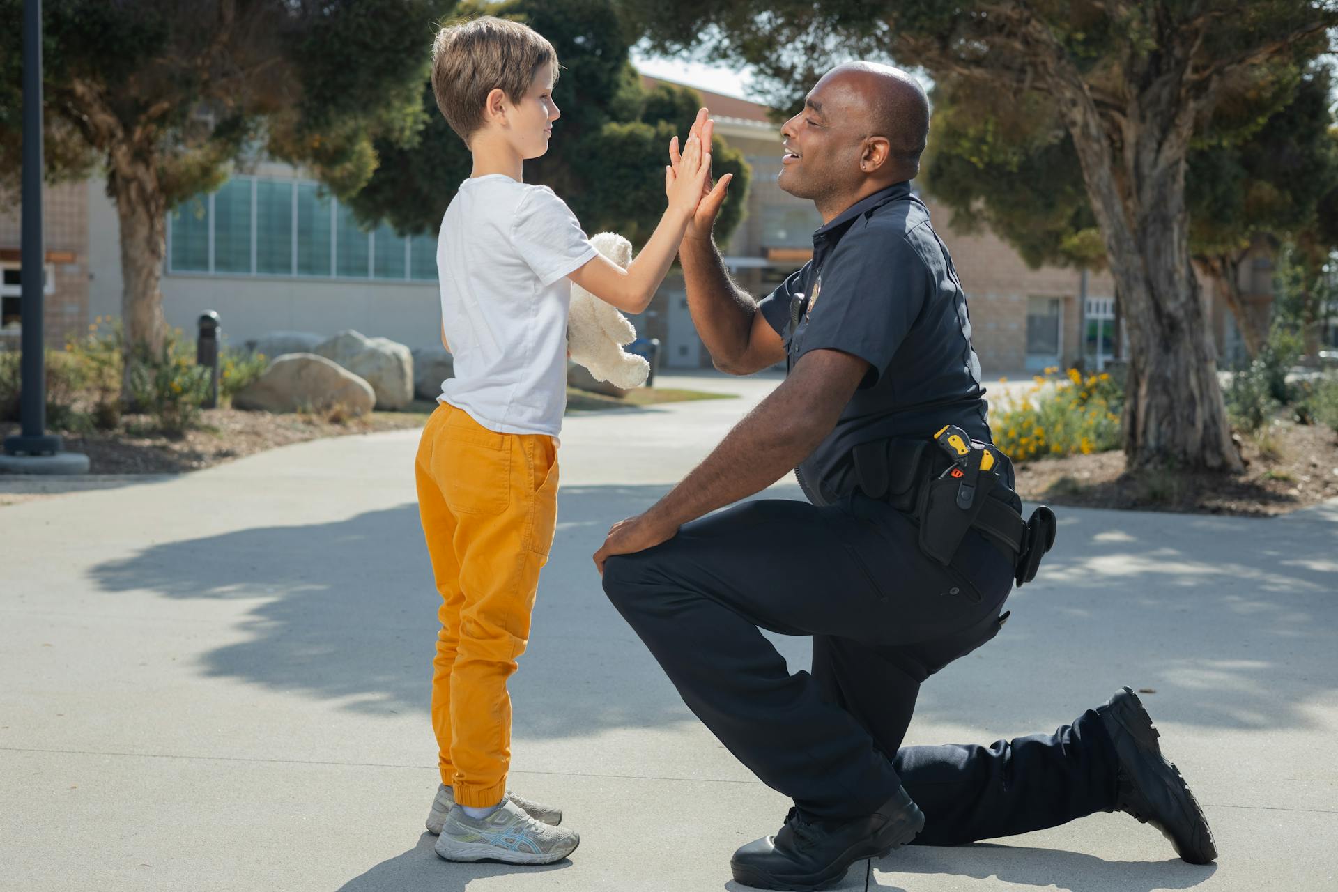 Ein Polizeibeamter, der einem Jungen ein High-Five gibt | Quelle: Pexels