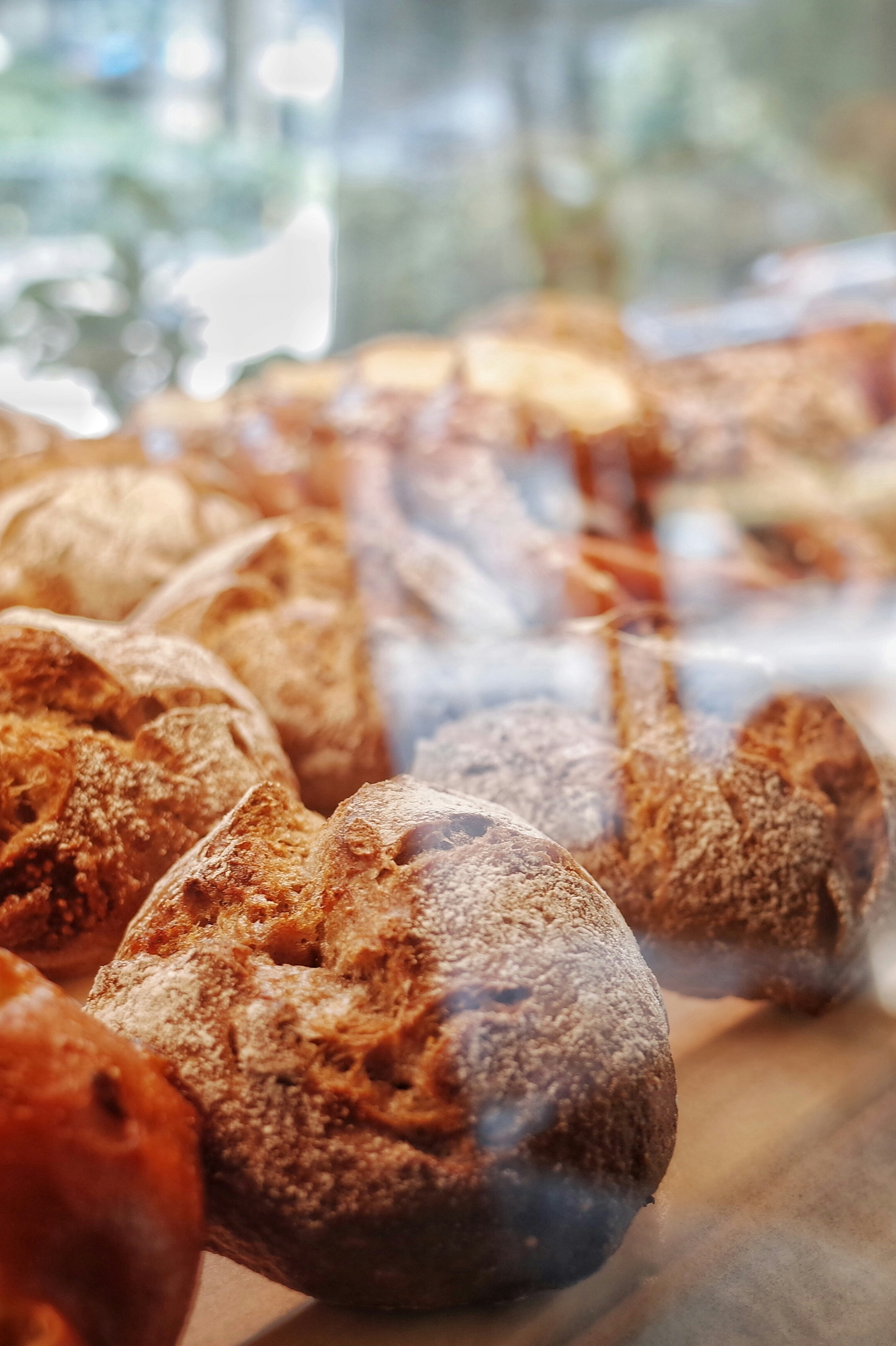 Eine Nahaufnahme von Brötchen, die in einer Bäckerei ausgestellt sind | Quelle: Unsplash