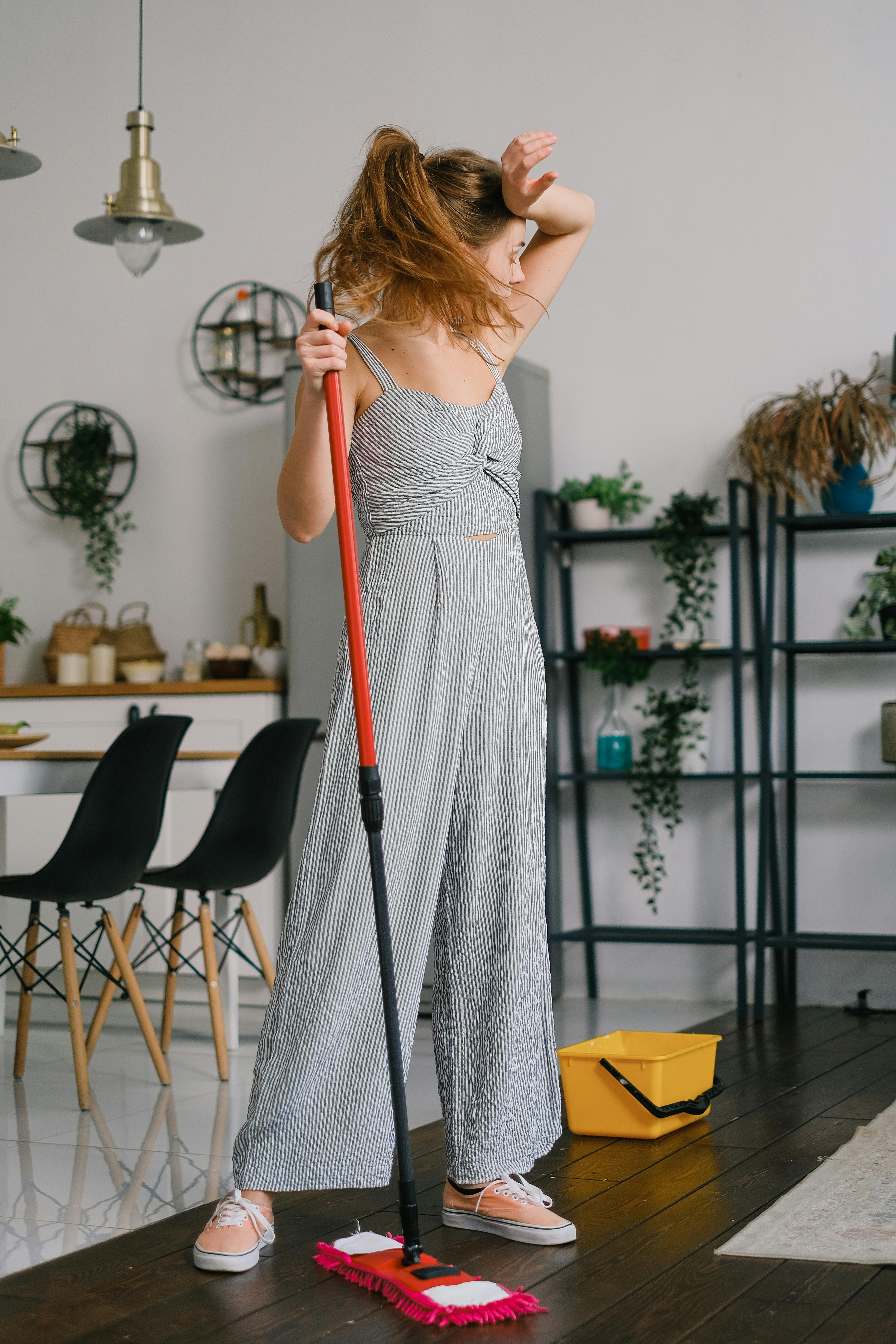 Müde Frau mit einem Wischmopp bei der Hausarbeit | Quelle: Pexels