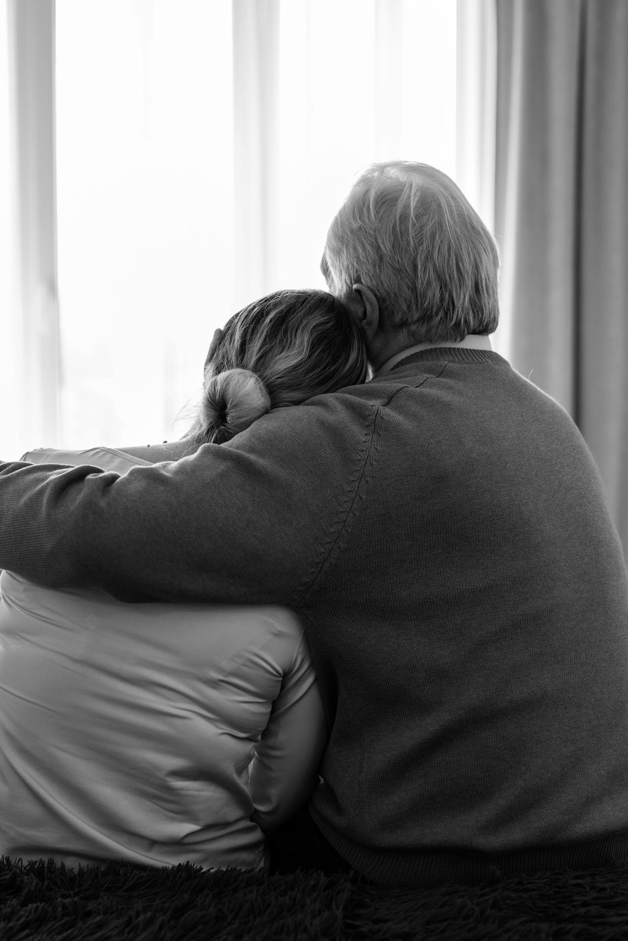 Eine Frau lehnt sich an die Schulter ihres Partners, während er sie umarmt | Quelle: Pexels