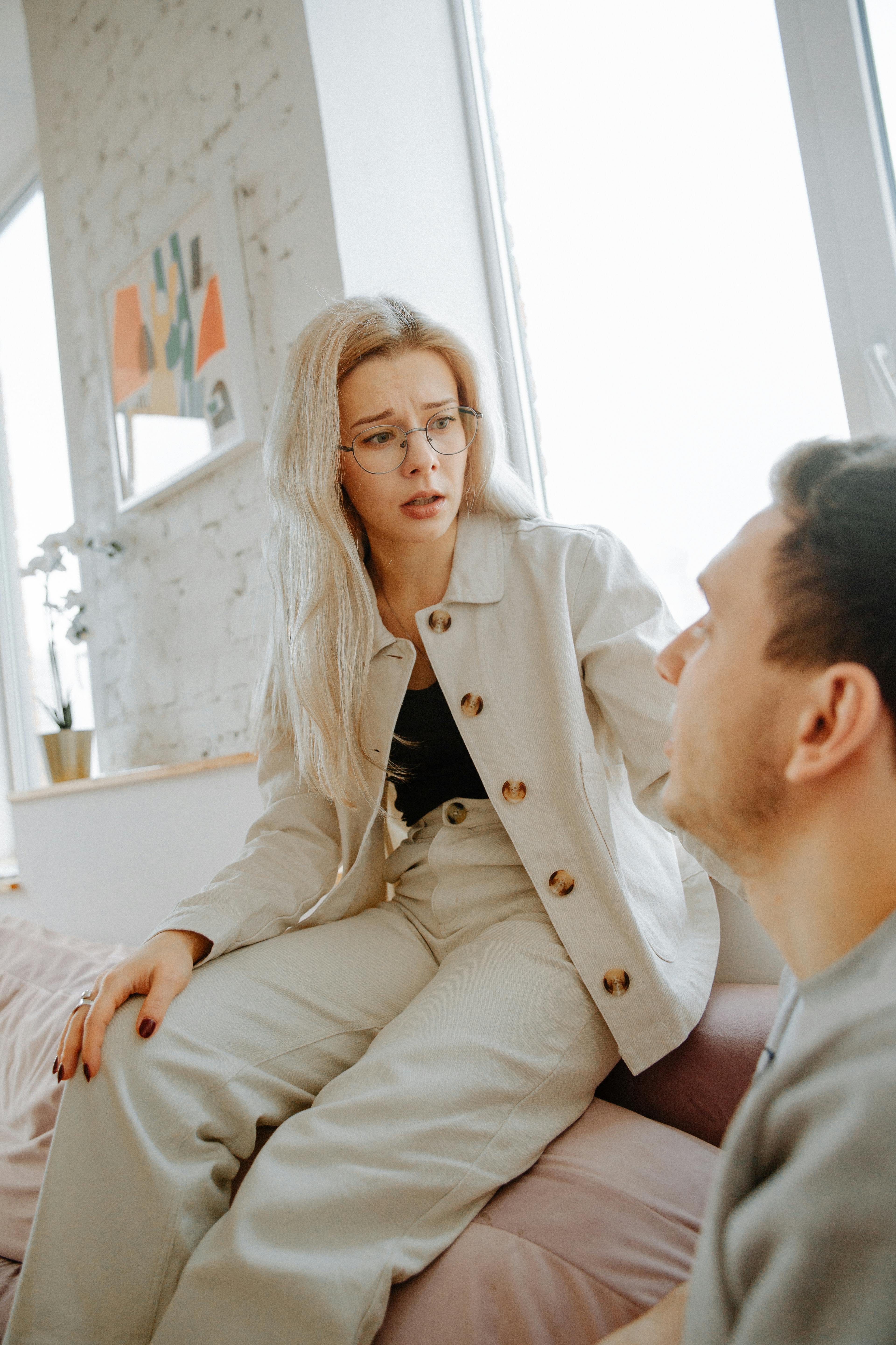 Eine traurig aussehende Frau im Gespräch mit einem Mann | Quelle: Pexels