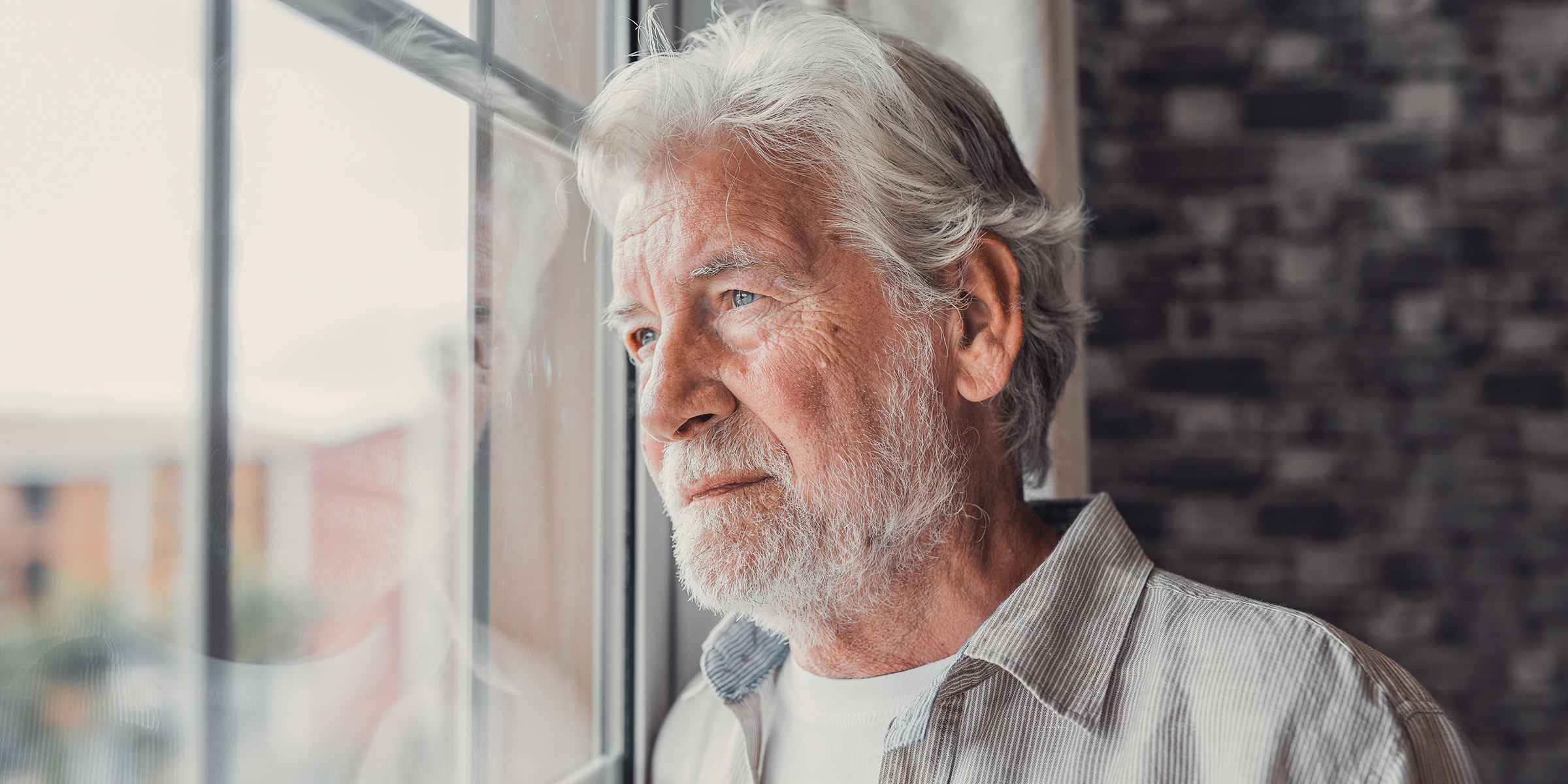 Ein älterer Mann, der nachdenklich an einem Fenster steht | Quelle: Amomama