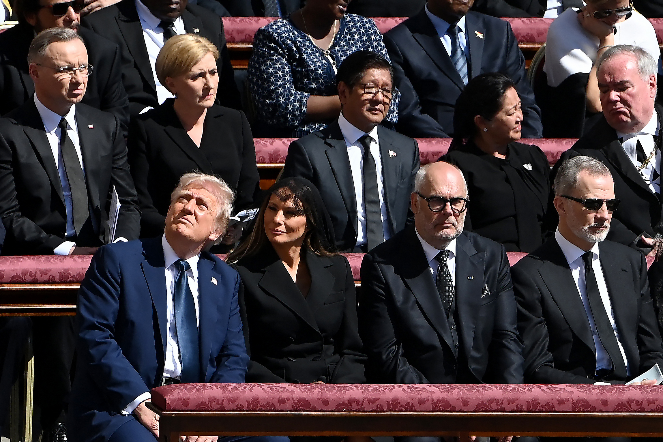 Donald und Melania Trump schauen sich etwas an, während sie neben Alar Karis und König Felipe VI. sitzen. | Quelle: Getty Images