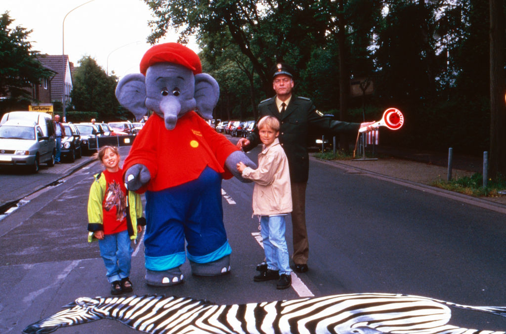 Die beliebte Comic- und Hörspielfigur Benjamin Blümchen dreht mit einem Polizisten und Kindern einen Verkehrserziehungsspot, Deutschland 1998 | Quelle: Getty Images