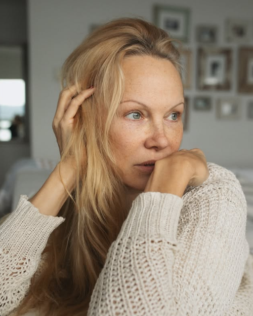 Pamela Anderson stützt ihr Kinn in die Hände – ein nachdenkliches Porträt ohne Make-up, gekleidet in einen kuscheligen, cremefarbenen, locker gestrickten Pullover. Während sie sanft mit der Hand durch ihr lockeres blondes Haar fährt, vor dem Hintergrund einer sanft unscharfen Galeriewand mit Familienfotos, strahlt sie jene ruhige Selbstsicherheit und authentische Schönheit aus, die ihr Kapitel bei Arcady prägen. Zu dieser intimen Nahaufnahme fügte sie den nachdenklichen Satz hinzu: „Solange wir lernen – sind wir auf dem richtigen Weg… 🤍✨“. | Quelle: Instagram/pamelaanderson
