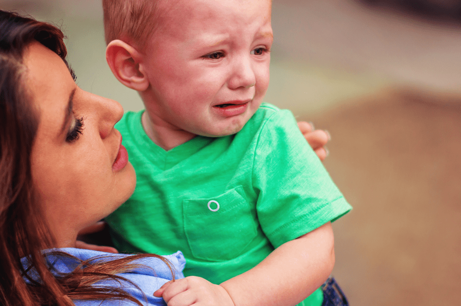 Eine Frau hält ein weinendes Baby. | Quelle: Shutterstock