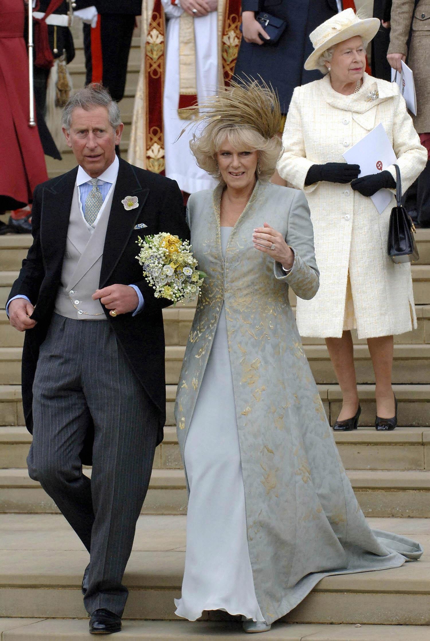 Königin Elizabeth II. abgebildet hinter Prinz Charles und seiner Frau Camilla, Herzogin of Cornwall, die nach der kirchlichen Segnung ihrer standesamtlichen Trauung am 9. April 2005 die Stufen der St. George's Chapel in Windsor hinuntergehen | Quelle: Getty Images