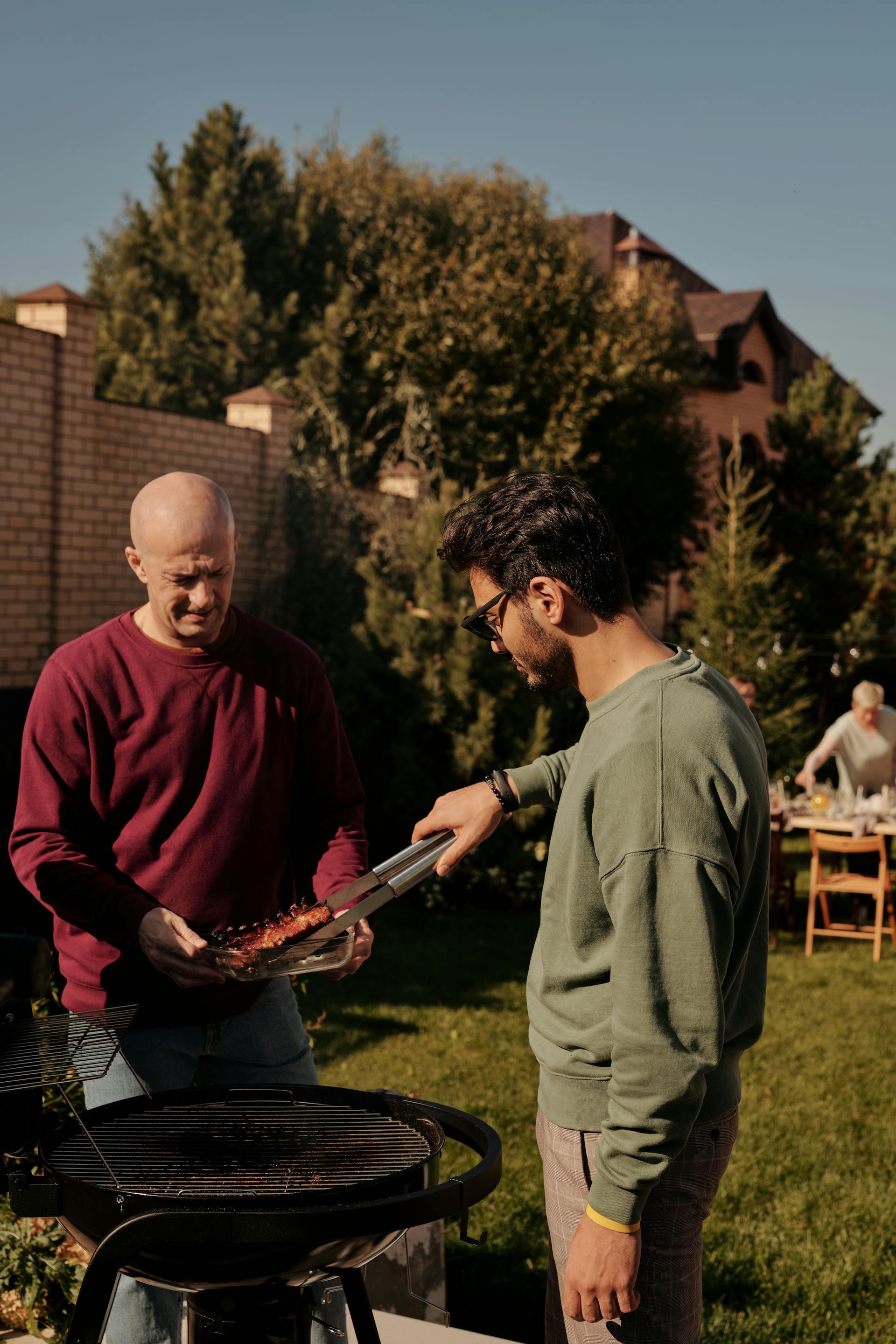 Zwei Männer beim Grillen im Hinterhof | Quelle: Pexels