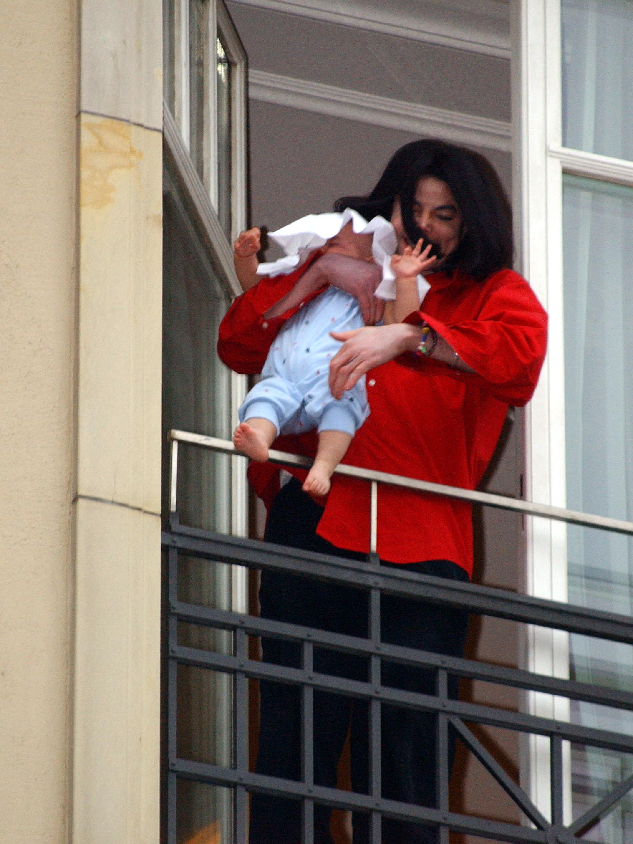 Michael Jackson hält seinen acht Monate alten Sohn Prince Michael II auf dem Balkon des Adlon Hotels | Quelle: Getty Images