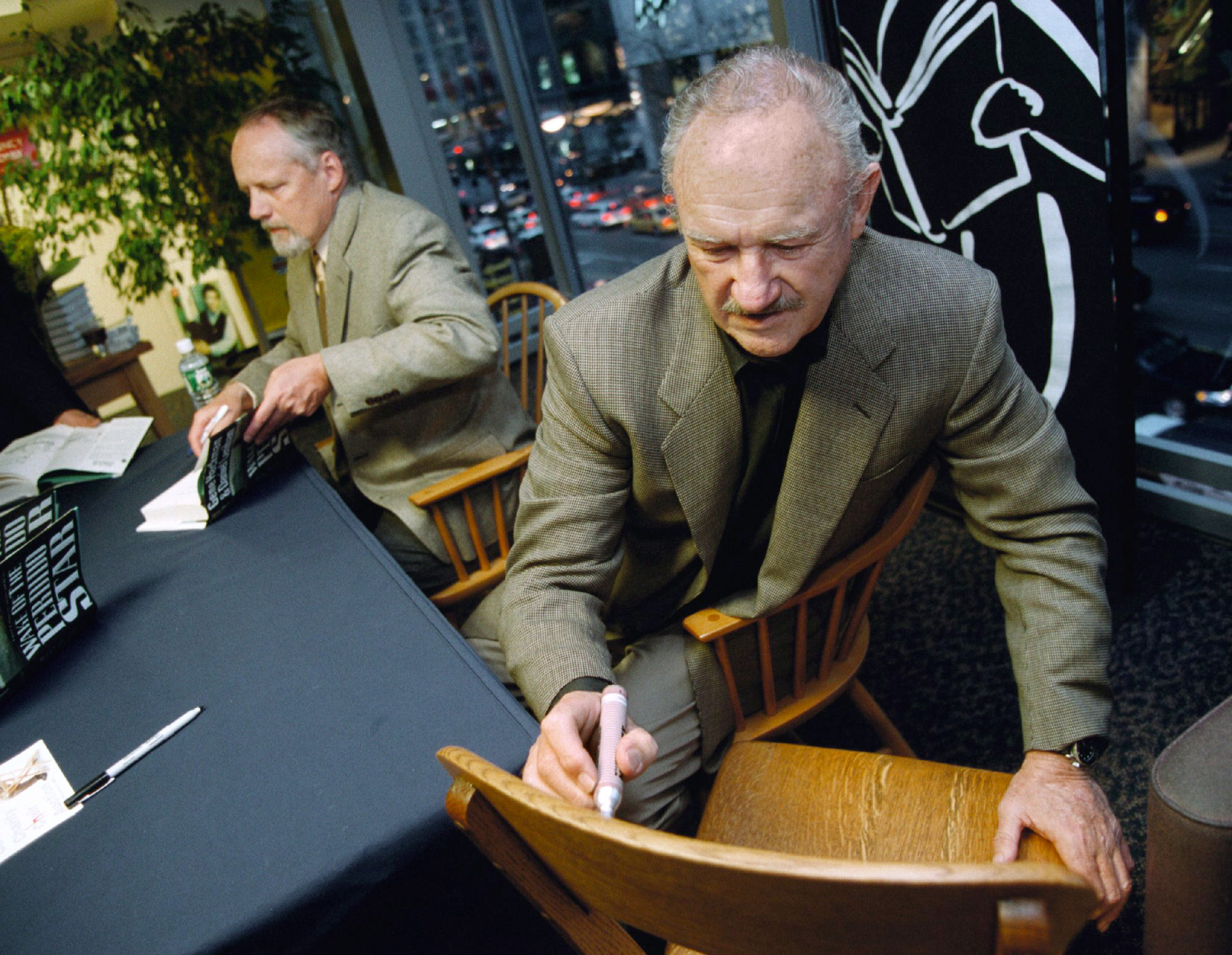 Gene Hackman signiert einen Stuhl für einen Fan, während er gleichzeitig Poster aus seinem Film "The French Connection" bei einem Borders Buchladen in Chicago signiert. 28. April 28 2000 | Quelle: Getty Images