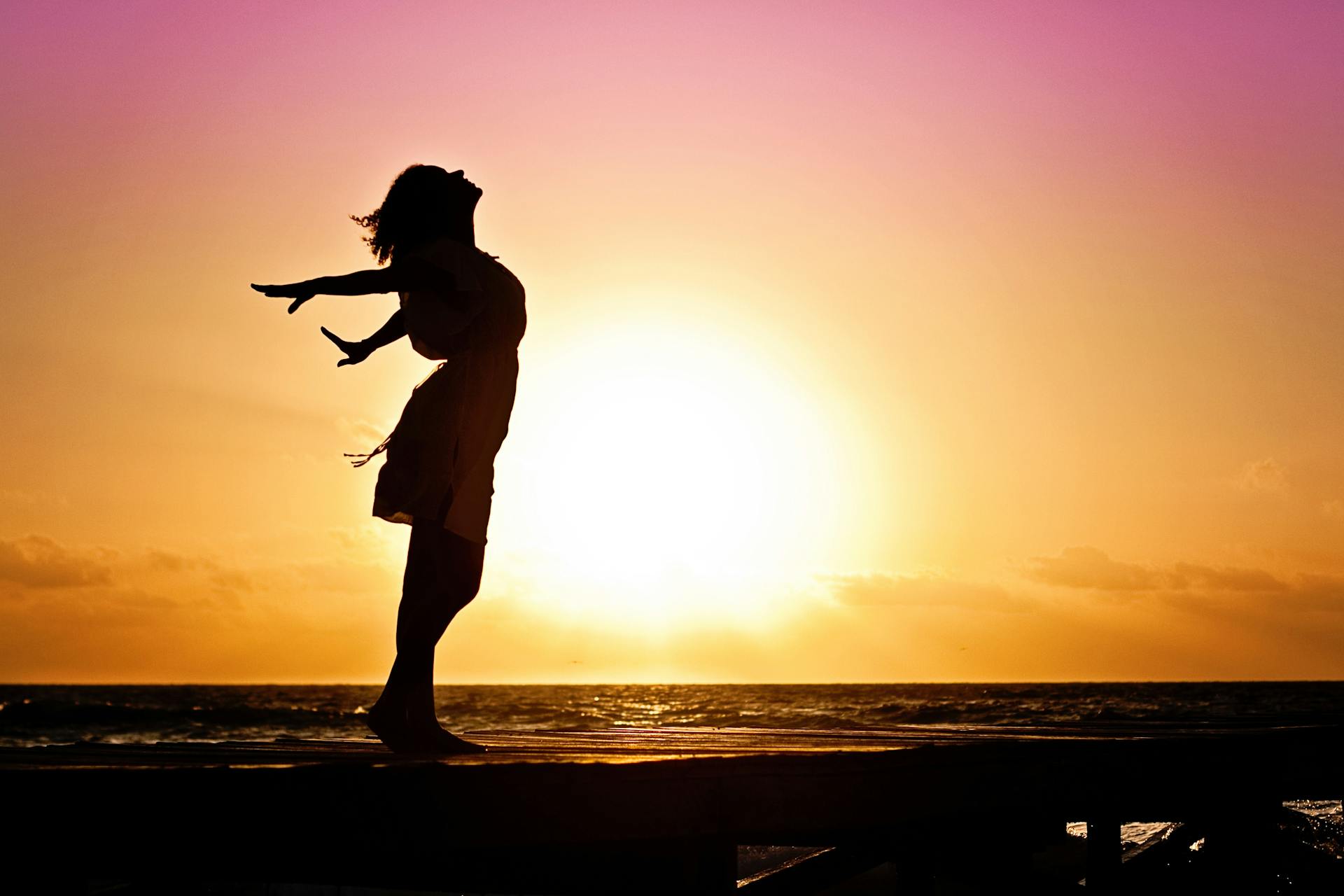 Silhouette einer unabhängigen und glücklichen Frau am Strand | Quelle: Pexels