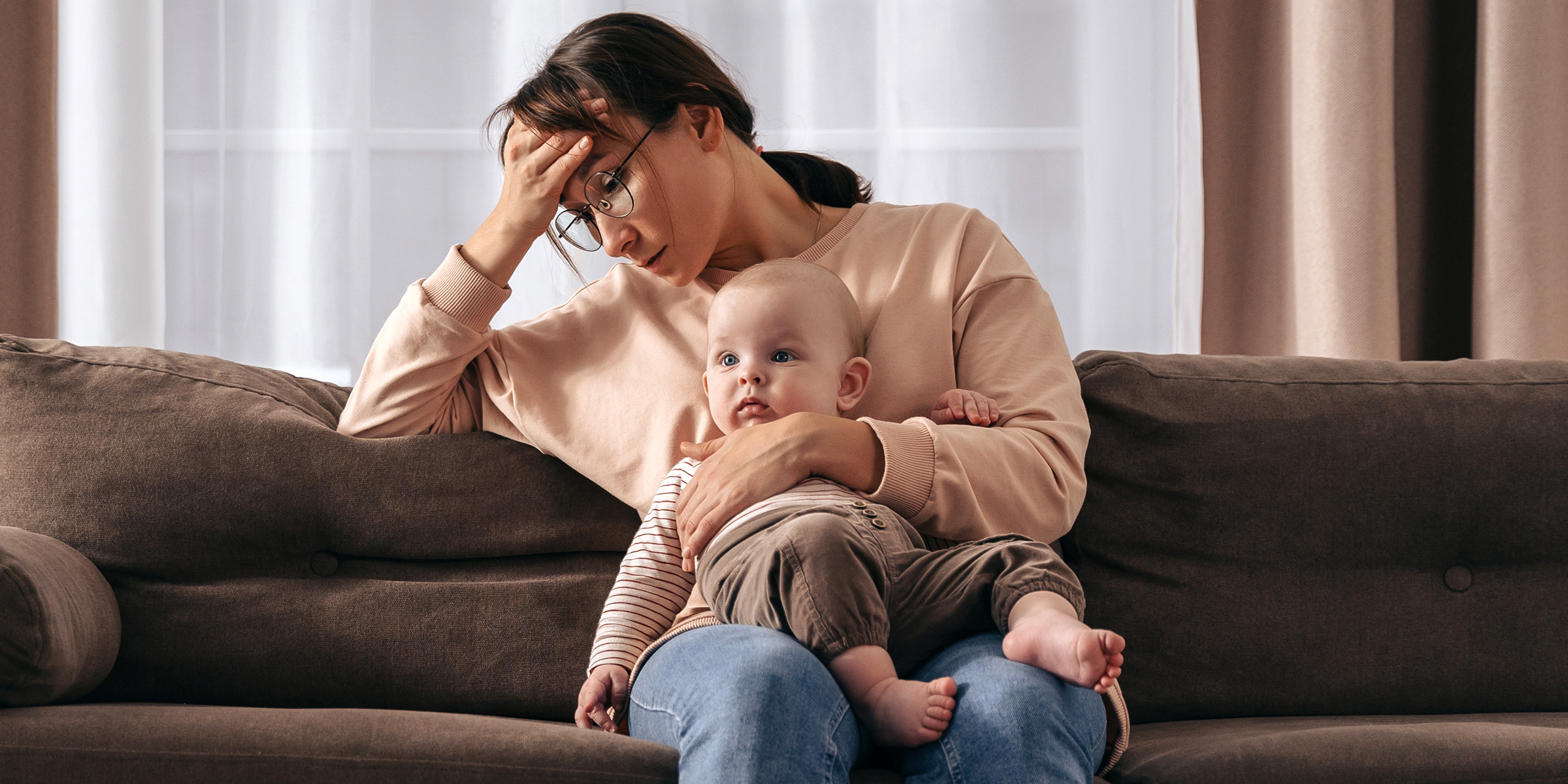 Eine traurige Frau mit einem Baby auf dem Schoß | Quelle: Shutterstock
