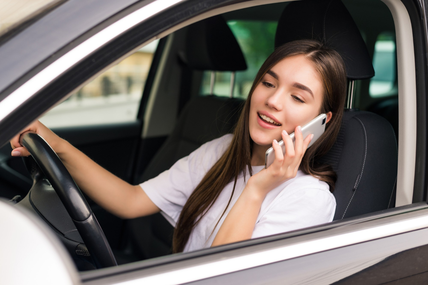 Eine erfreute Frau, die in ihrem Auto sitzt und telefoniert | Quelle: Freepik