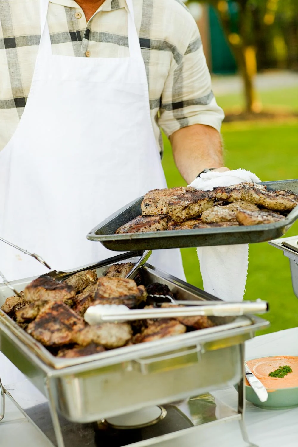 Ein Mann hält ein Tablett mit Fleisch | Quelle: Pexels