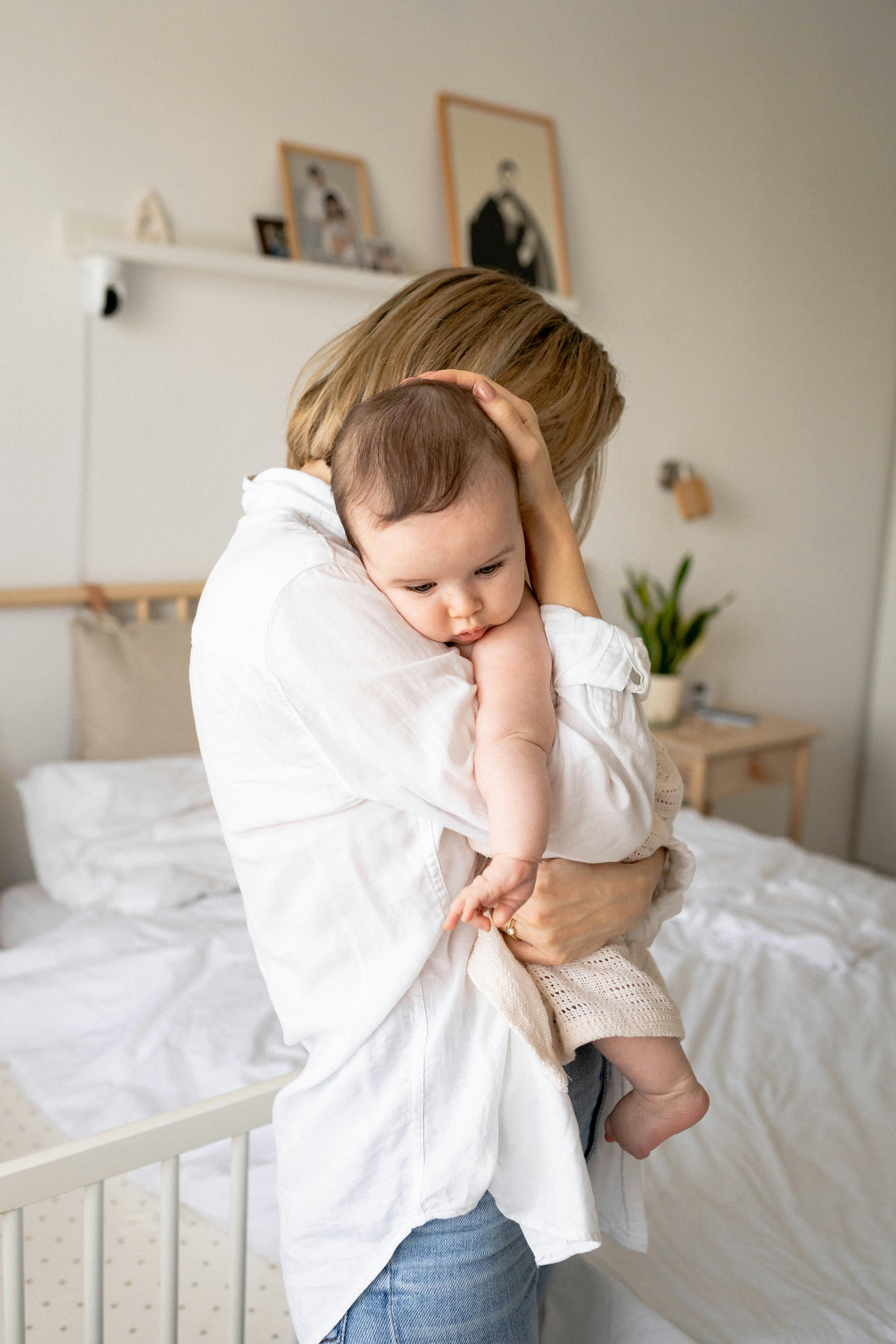 Eine Frau, die ihr Baby umarmt und festhält | Quelle: Pexels