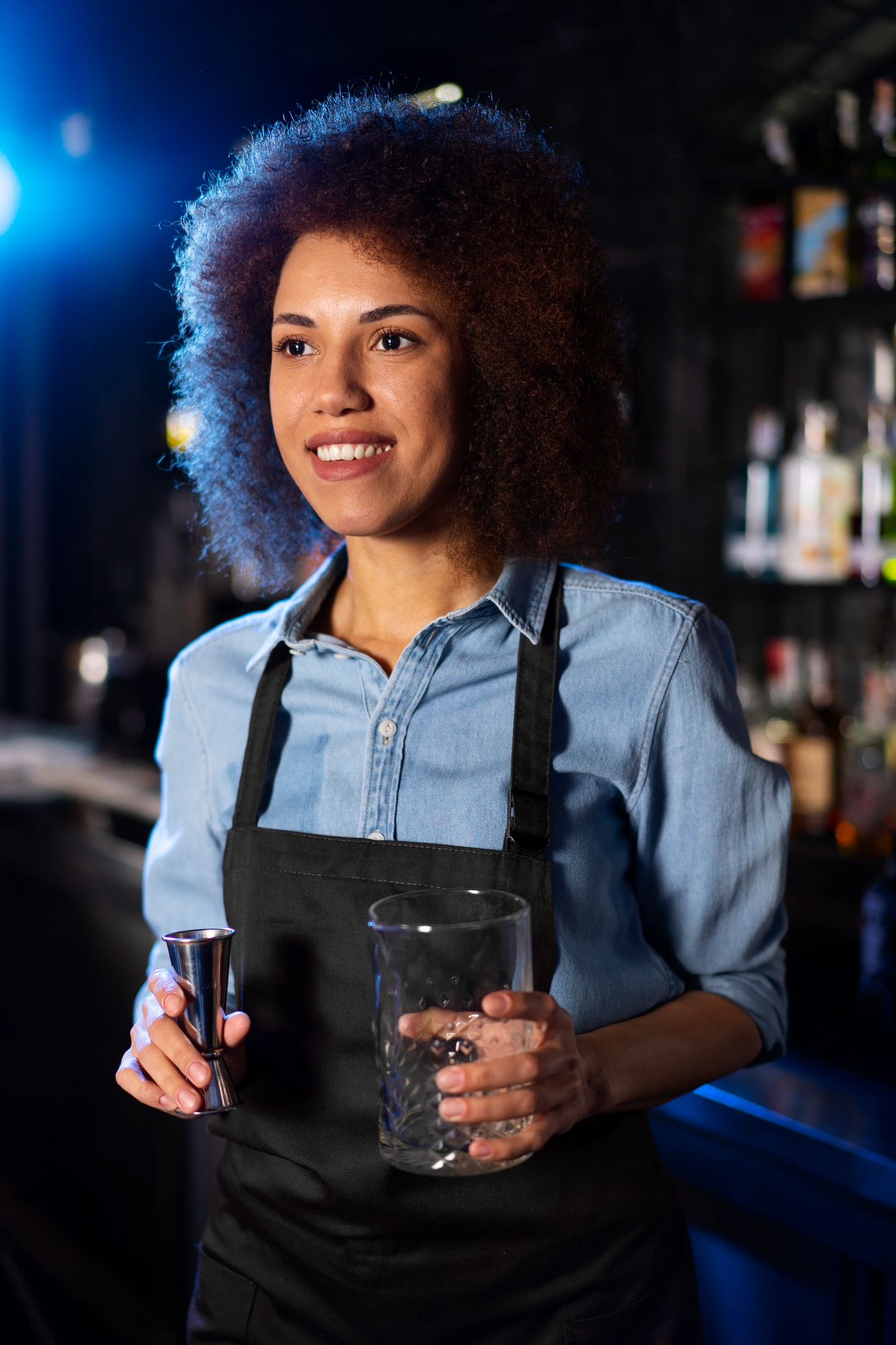 Ein glücklicher Kellner hält ein Glas und einen Ausgießer für ein Getränk | Quelle: Freepik