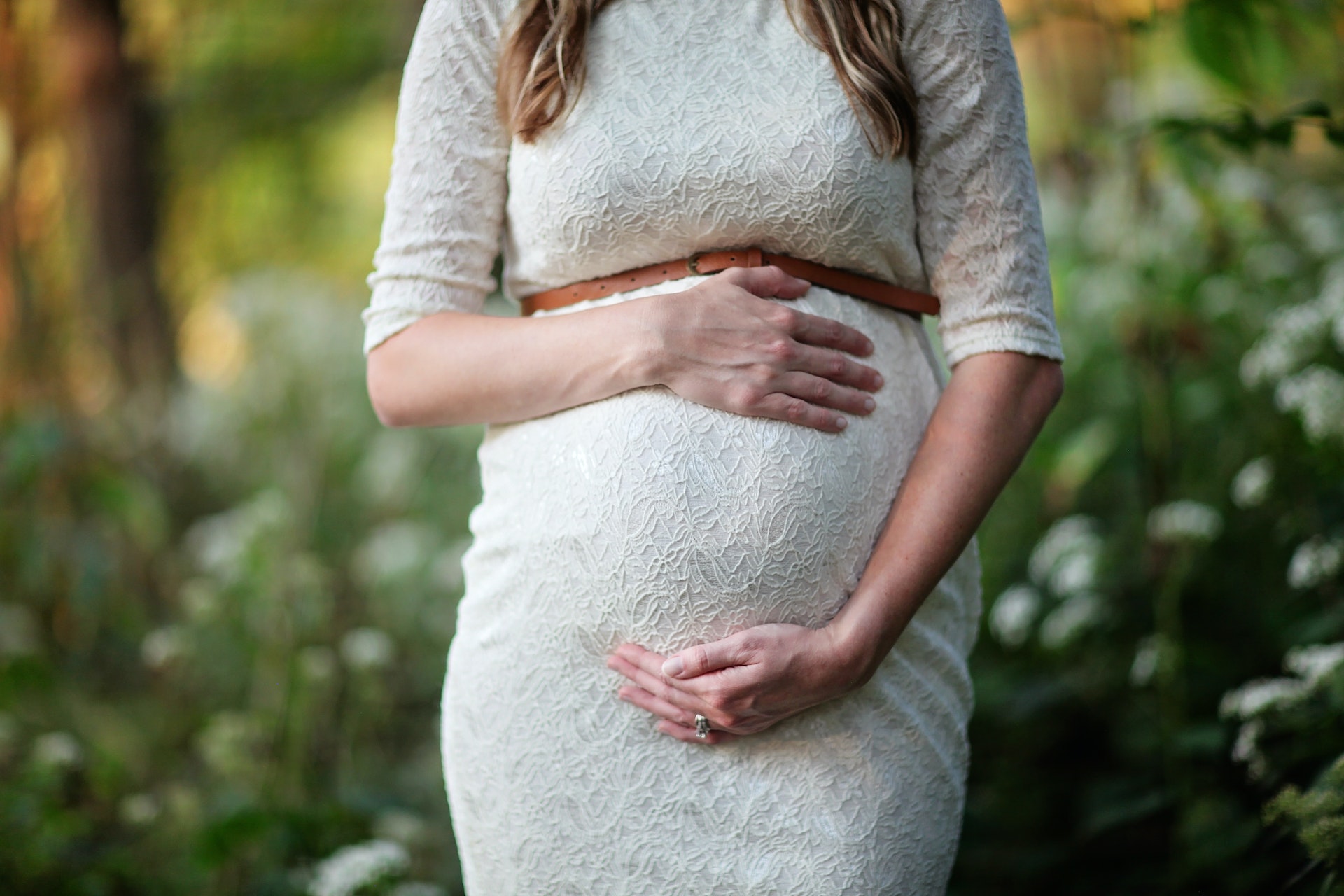 Eine schwangere Frau umkreist ihren Babybauch | Quelle: Pexels