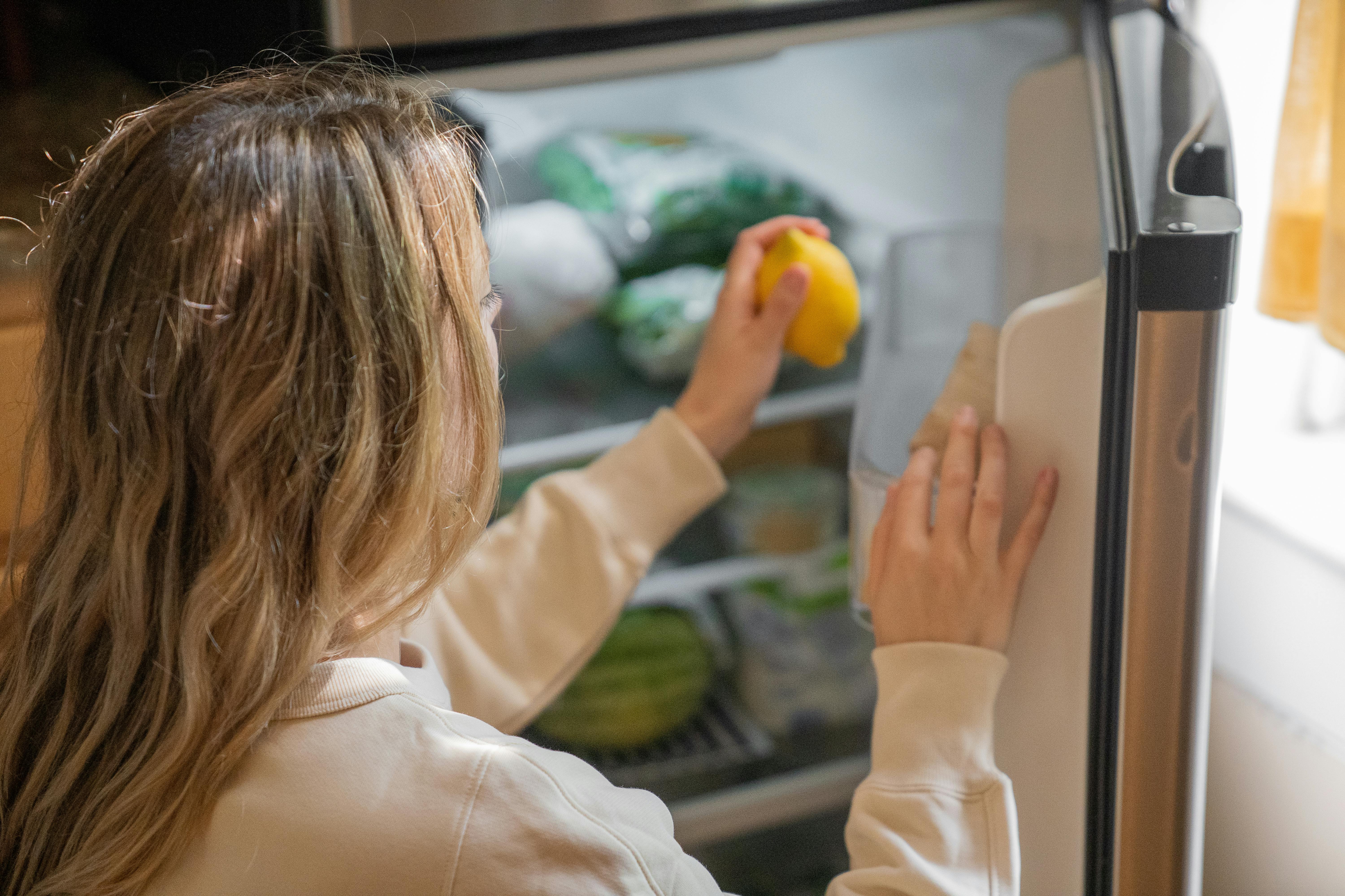 Eine Frau legt Lebensmittel in den Kühlschrank | Quelle: Pexels