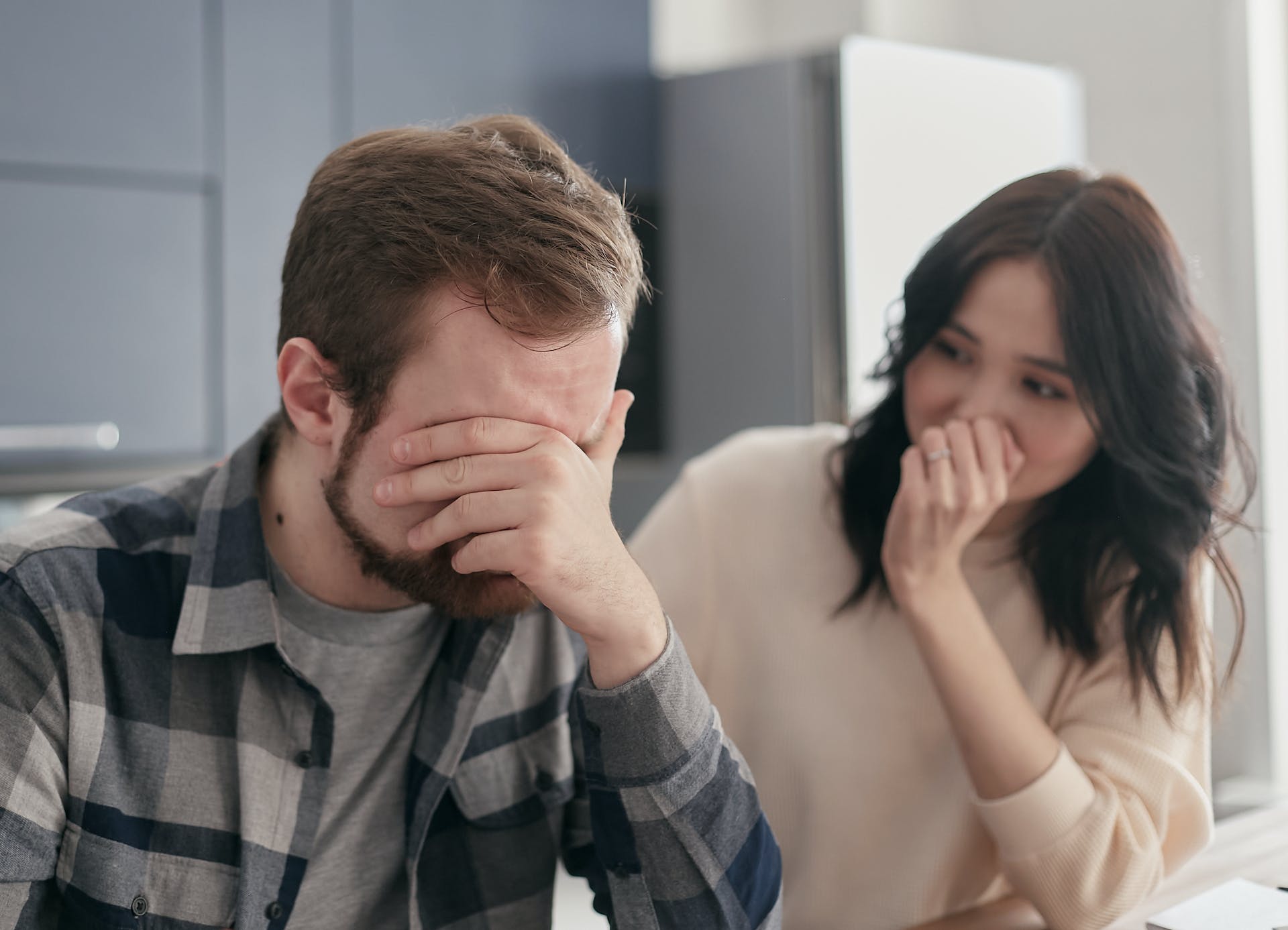 Eine Frau sieht zu, wie ihr Mann eine Hand auf seinem Gesicht ruht | Quelle: Pexels