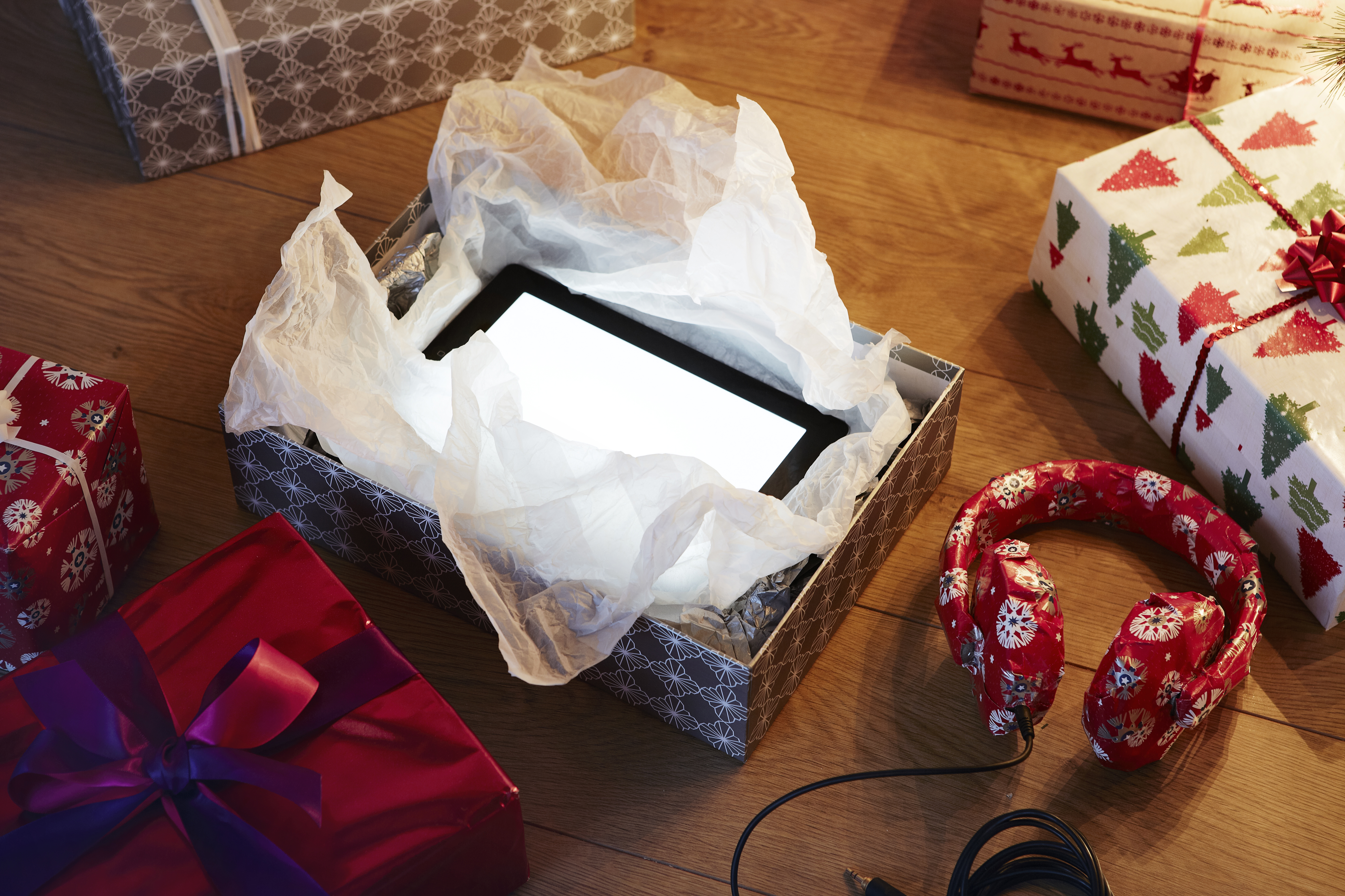 Ein ausgepacktes Weihnachtsgeschenk, das einen Tablet-Computer enthüllt | Quelle: Getty Images