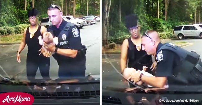 Ein Polizist nimmt ein Kind, das sich verschluckte auf den Arm und führt Wiederbelebungsmaßnahmen durch