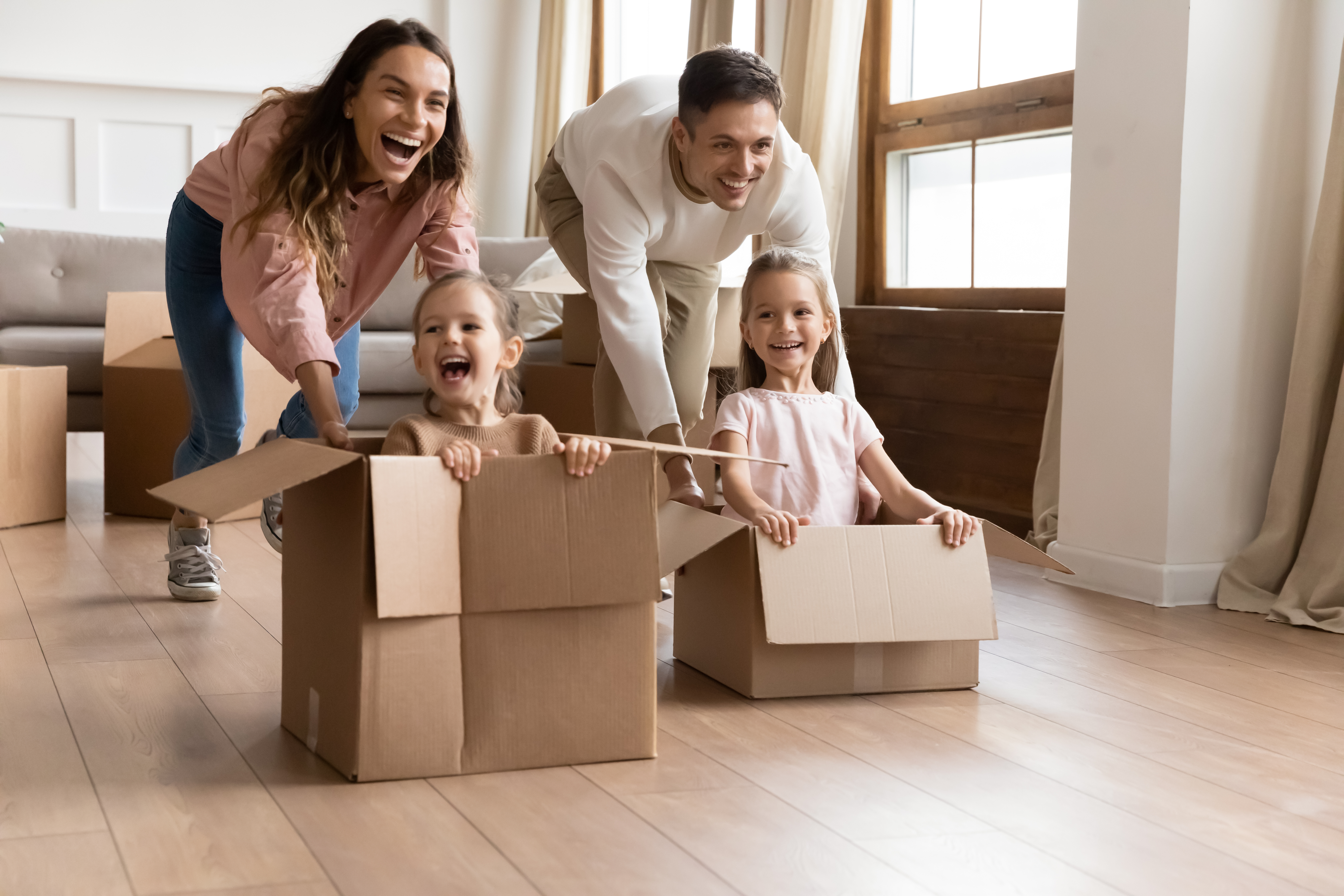 Glückliche Eltern spielen mit ihren Kindern im Wohnzimmer | Quelle: Shutterstock
