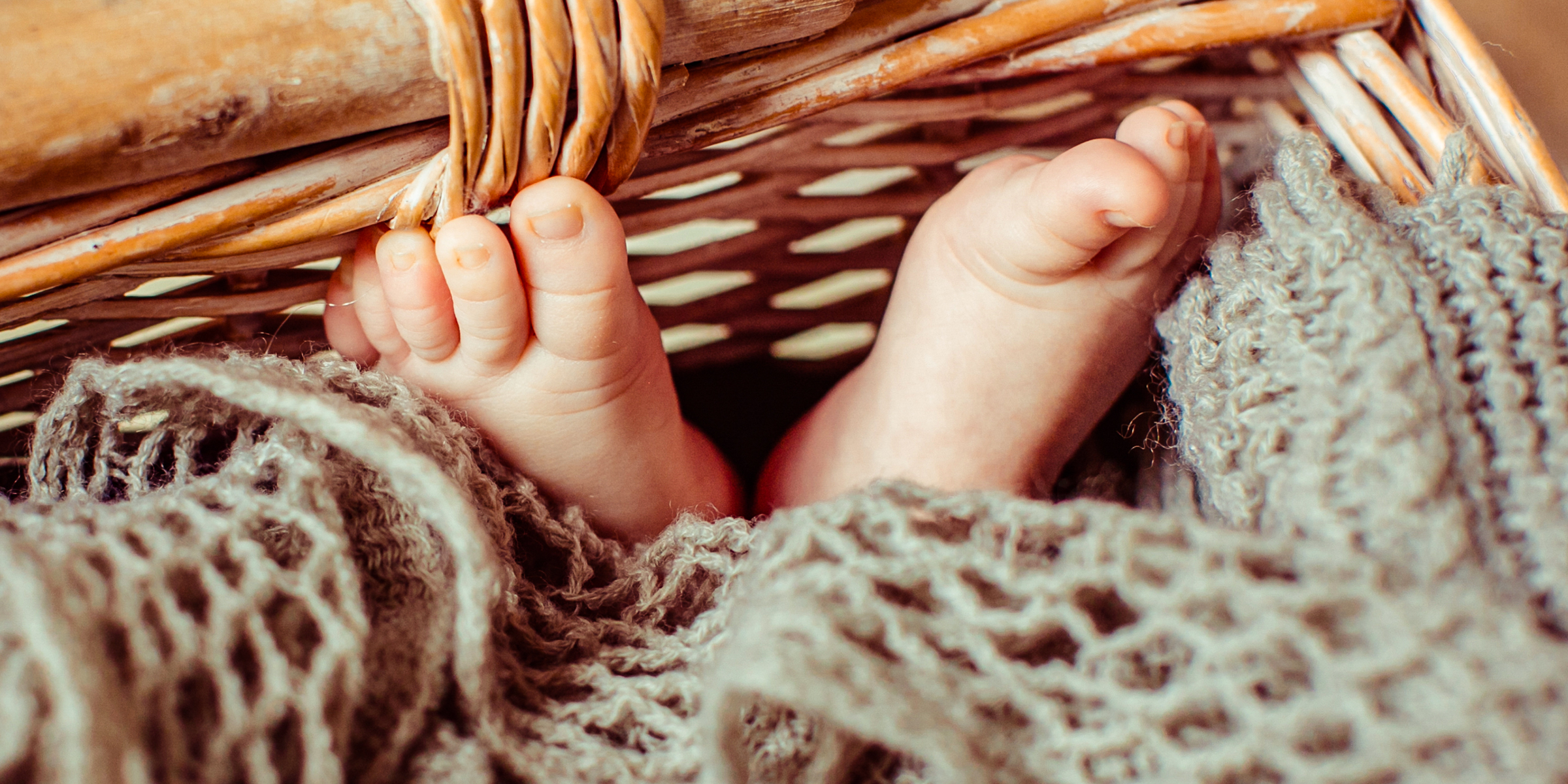 Füße eines Babys, das in einem Korb liegt | Quelle: Freepik