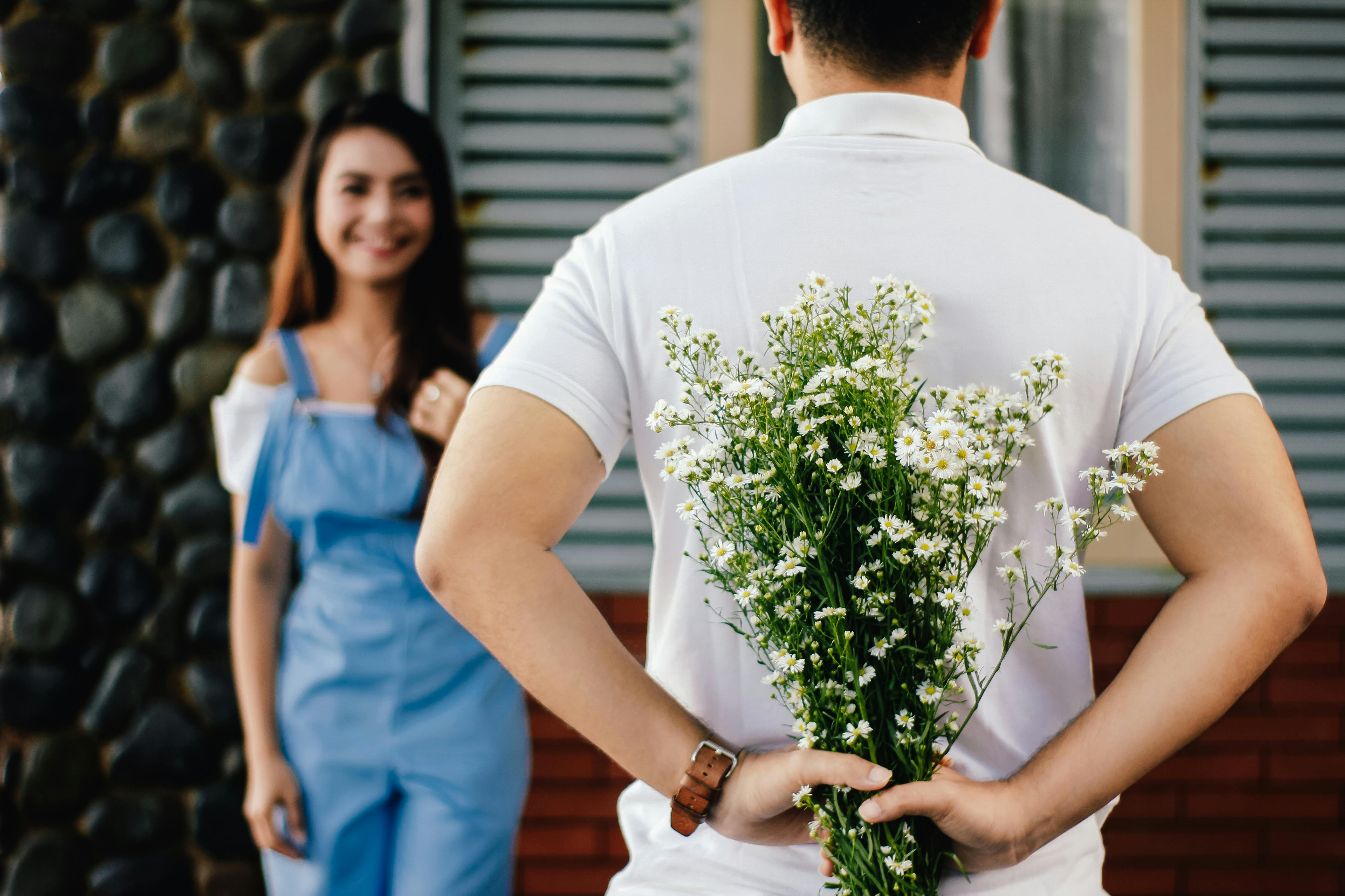 Ein Mann überrascht eine Frau mit Blumen | Quelle: Pexels