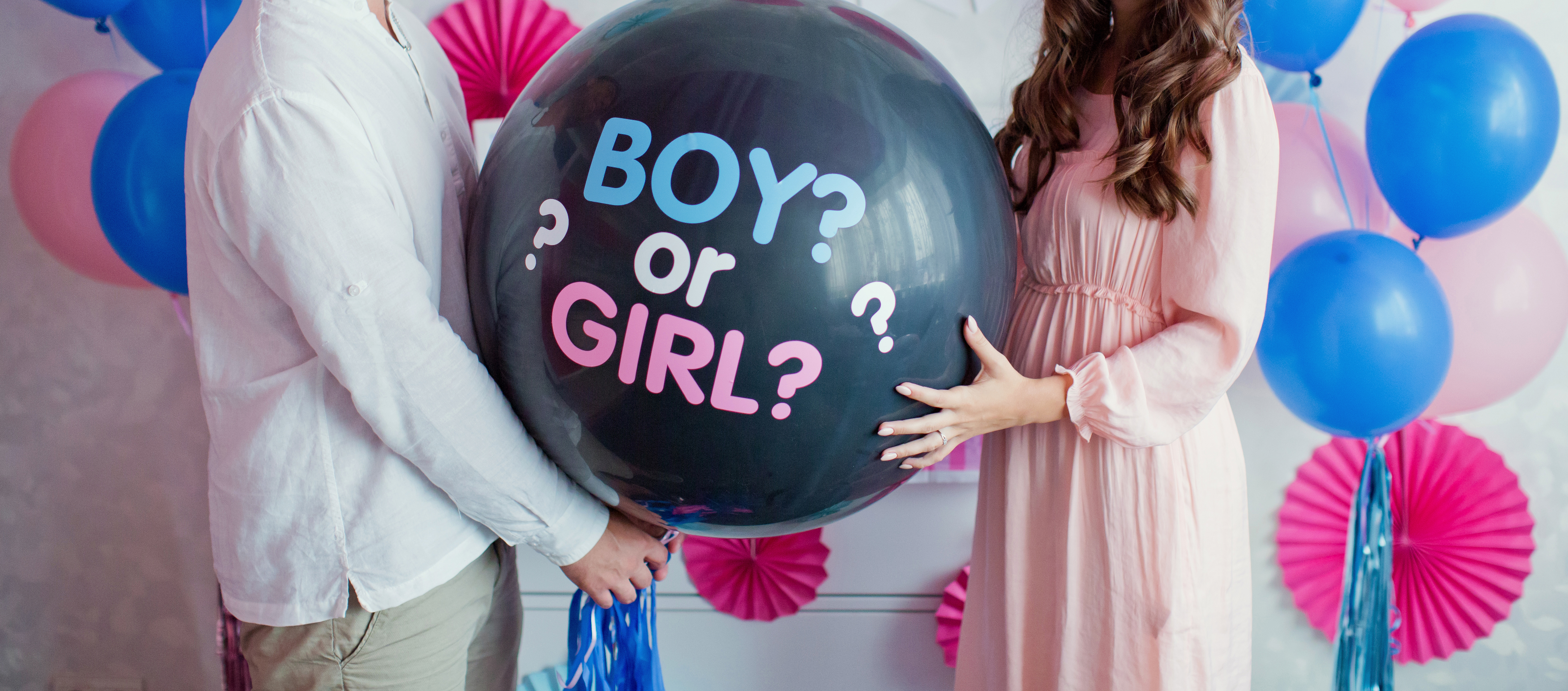 Ein Paar, das einen Luftballon mit der Aufschrift "Junge oder Mädchen" hält | Quelle: Shutterstock