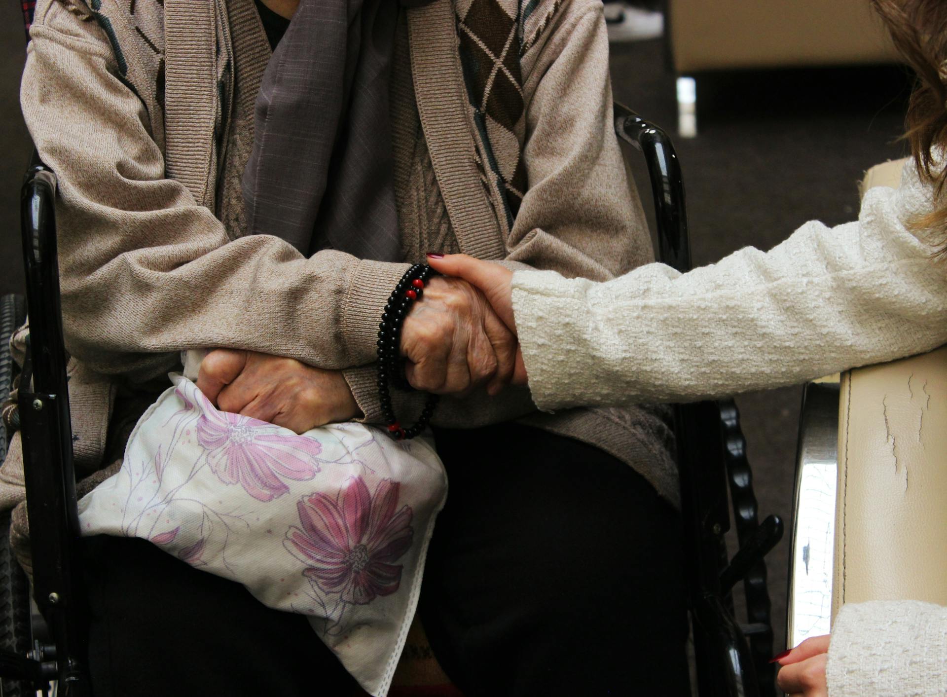 Eine junge Frau hält die Hand einer älteren Person | Quelle: Pexels
