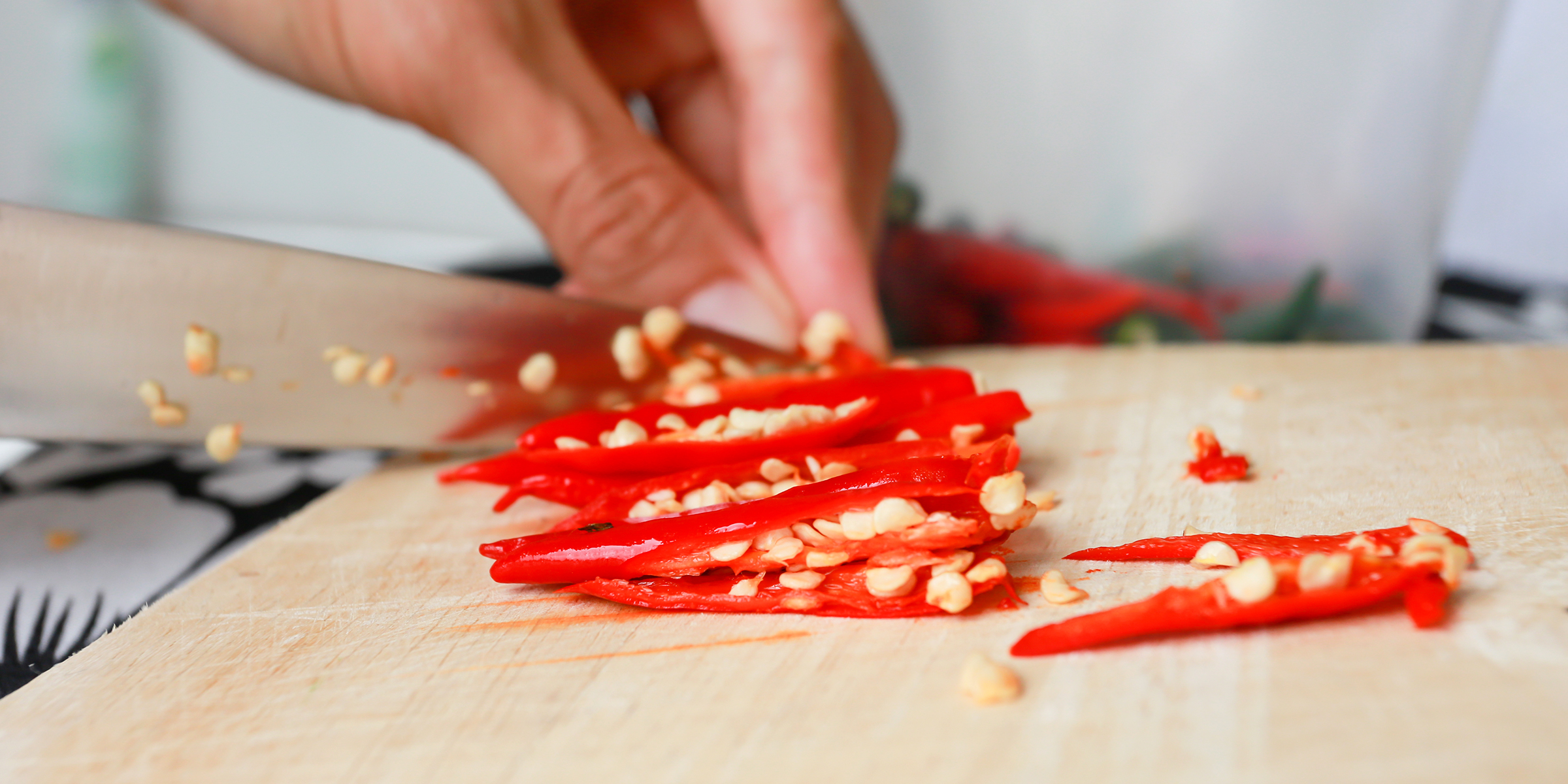 Eine Person, die ein Chili schneidet | Quelle: Shutterstock