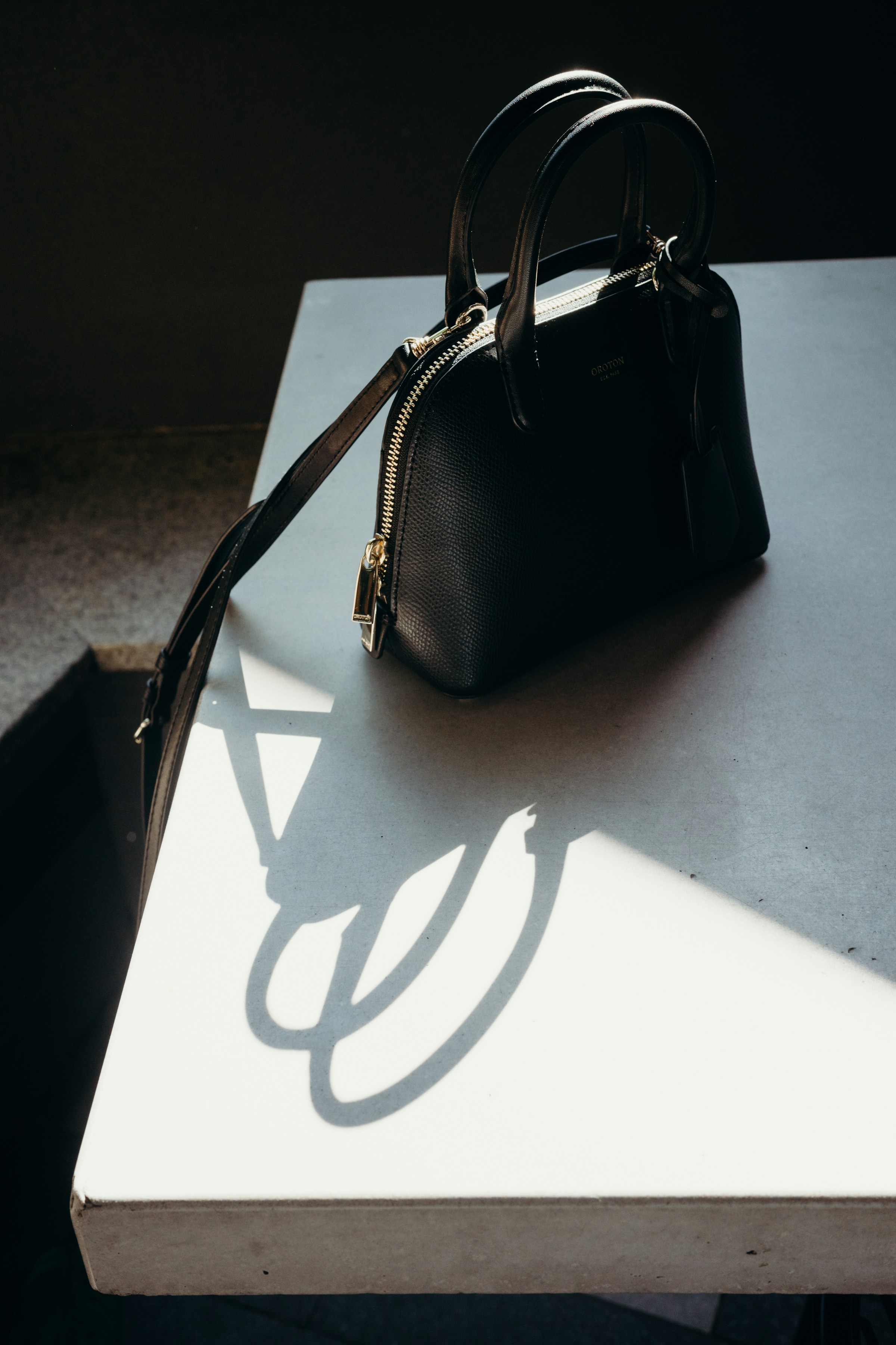 Eine schwarze Handtasche auf einem Tisch | Quelle: Unsplash