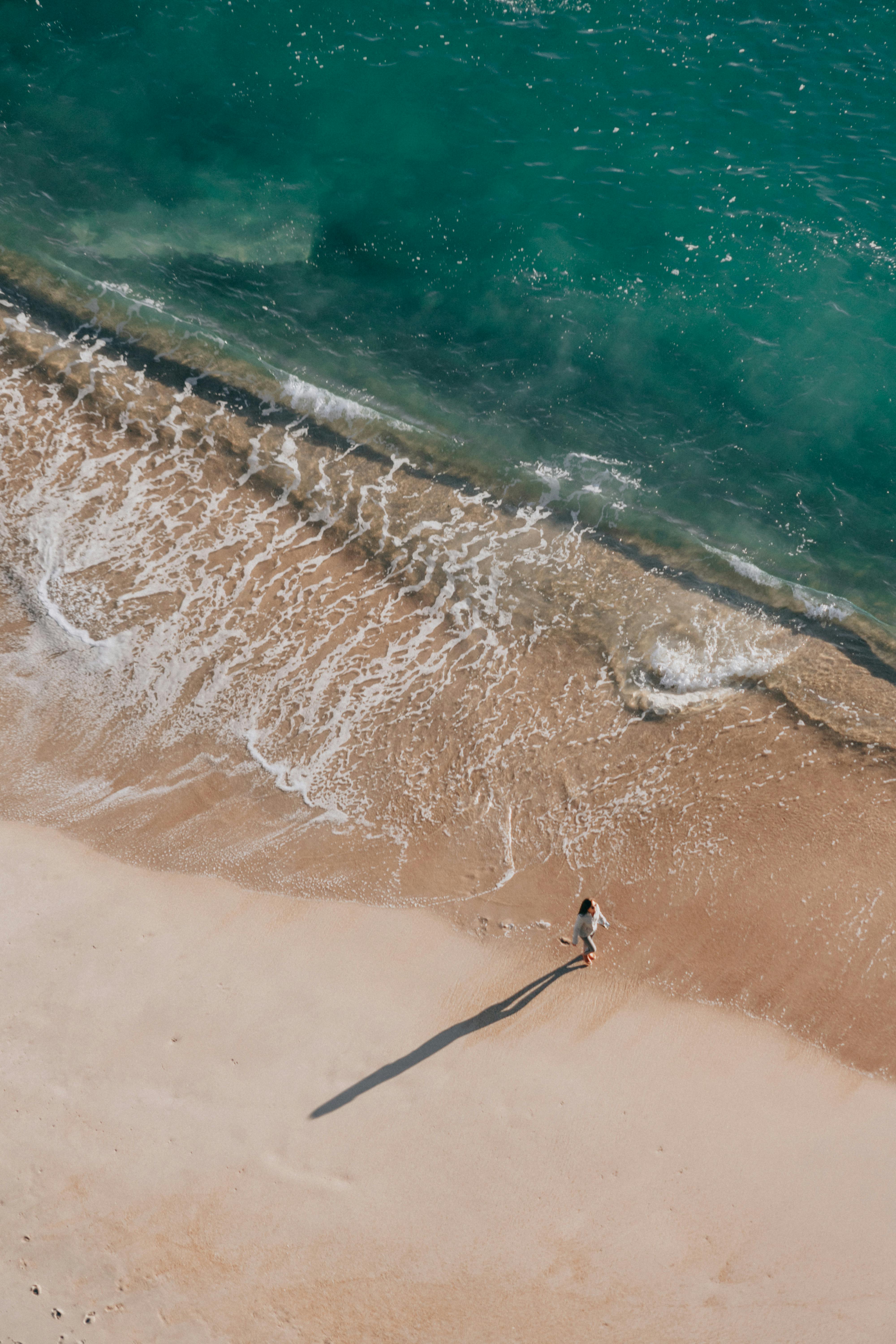 Eine Frau, die an einem Strand spazieren geht | Quelle: Pexels