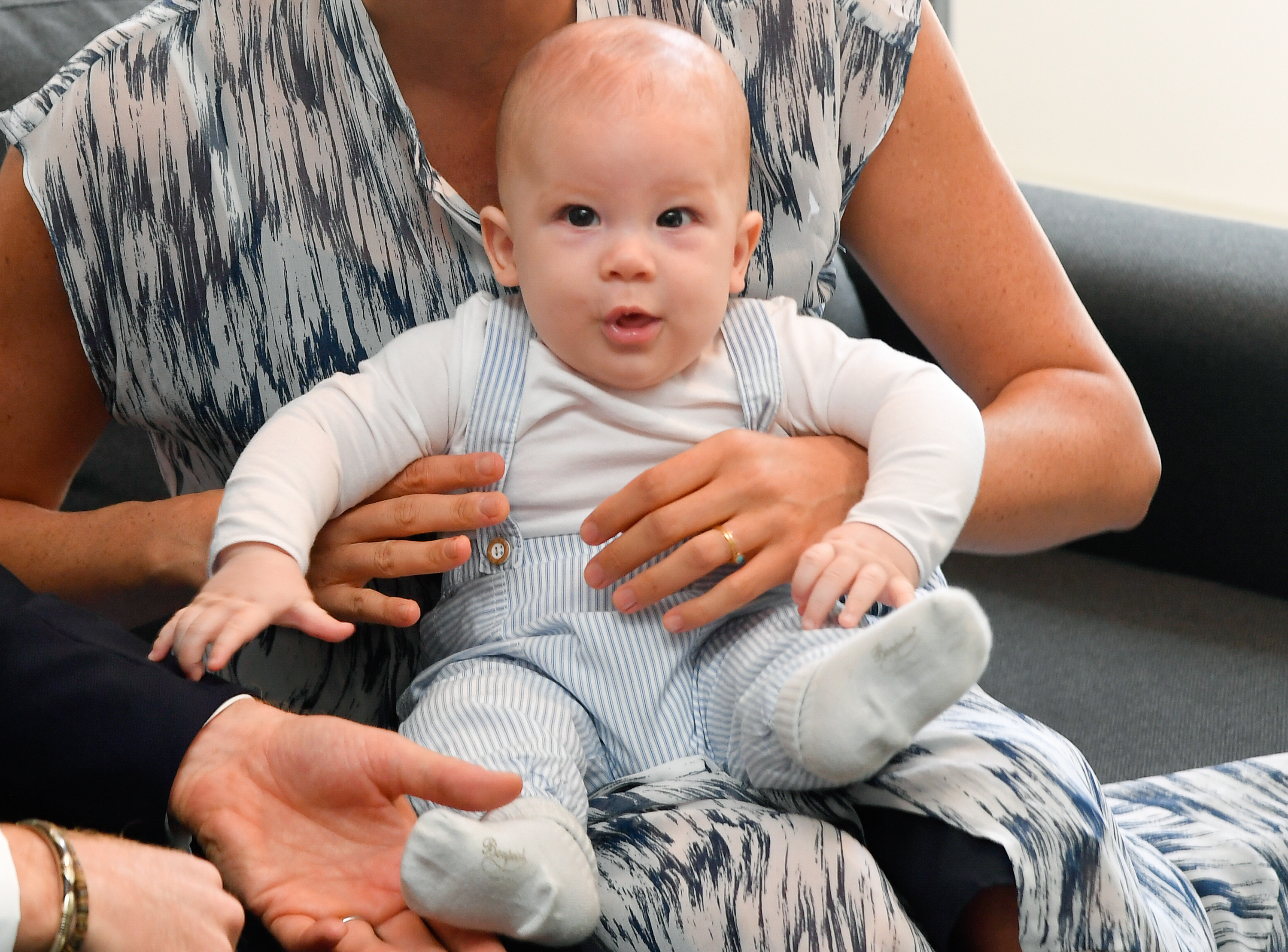 Während seiner ersten königlichen Reise nach Südafrika im September 2019 trug der vier Monate alte Archie einen blau-weiß gestreiften Overall, der dem Outfit, das Prinz Harry 1985 als Baby getragen hatte, auffallend ähnlich sah. Diese rührende Ähnlichkeit weckte Erinnerungen daran, wie Prinzessin Diana den kleinen Harry in seiner Kindheit im Arm hielt. | Quelle: Getty Images