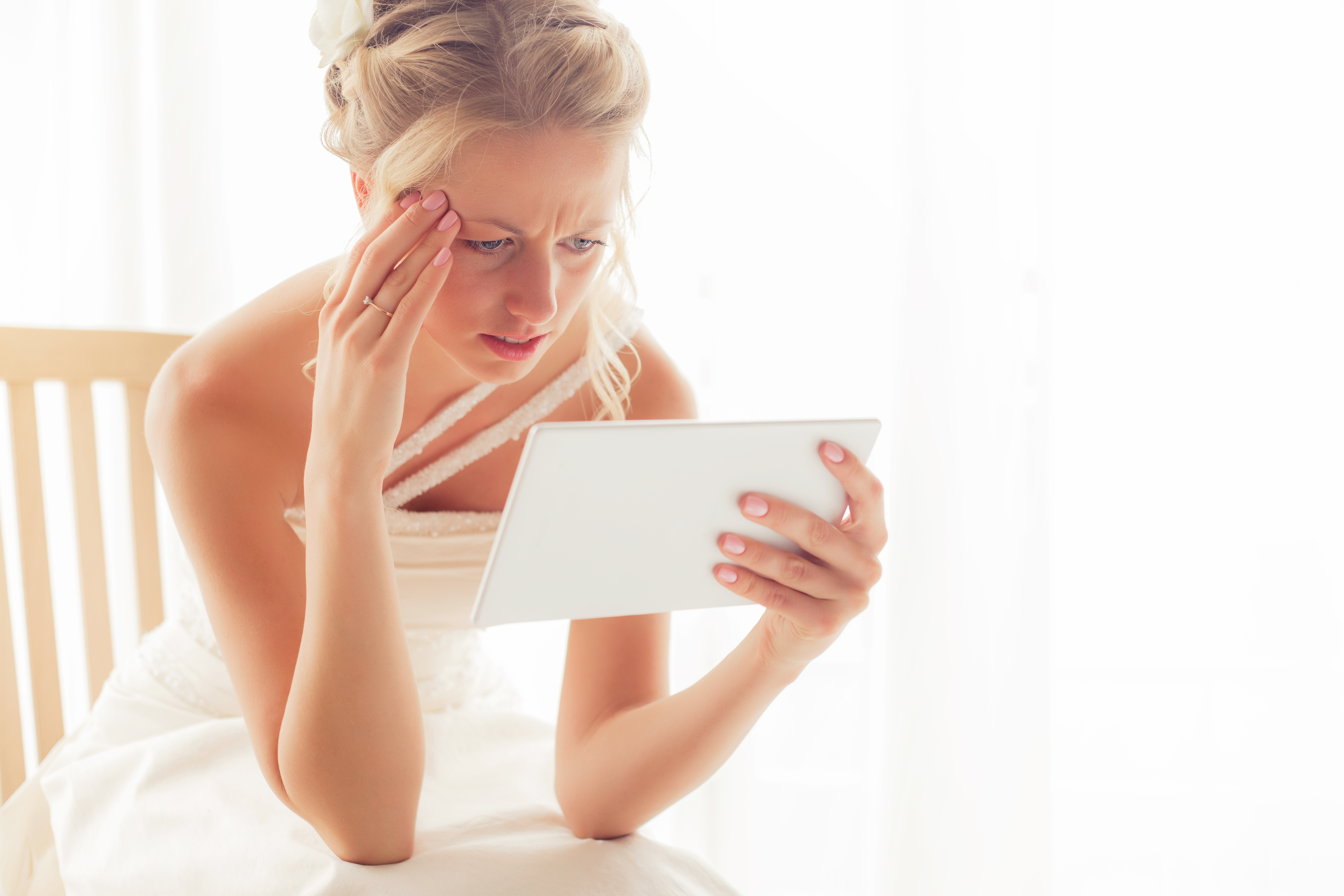 Eine besorgte Braut schaut auf ein Tablet | Quelle: Shutterstock