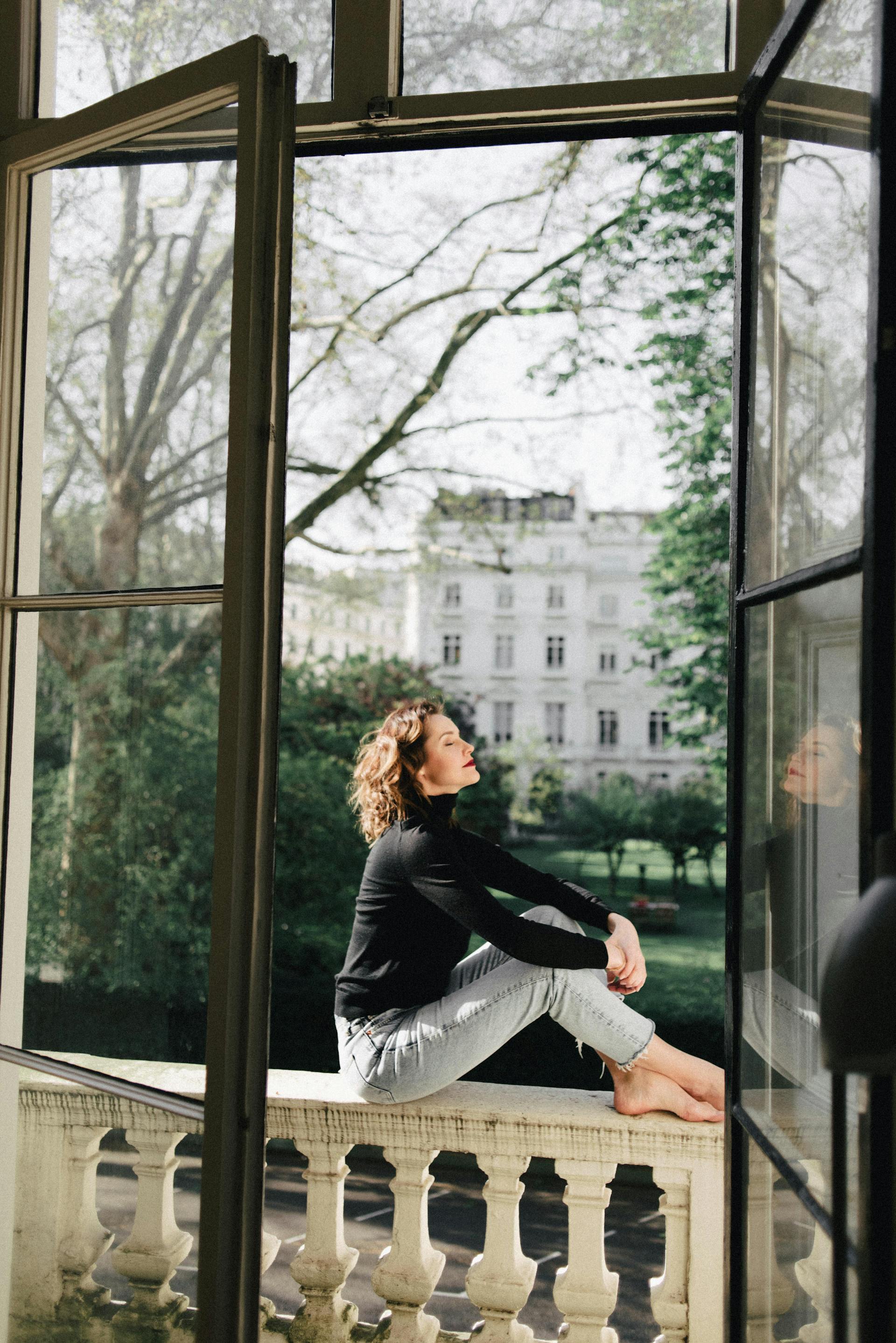 Eine Frau, die auf einem Balkon sitzt | Quelle: Pexels