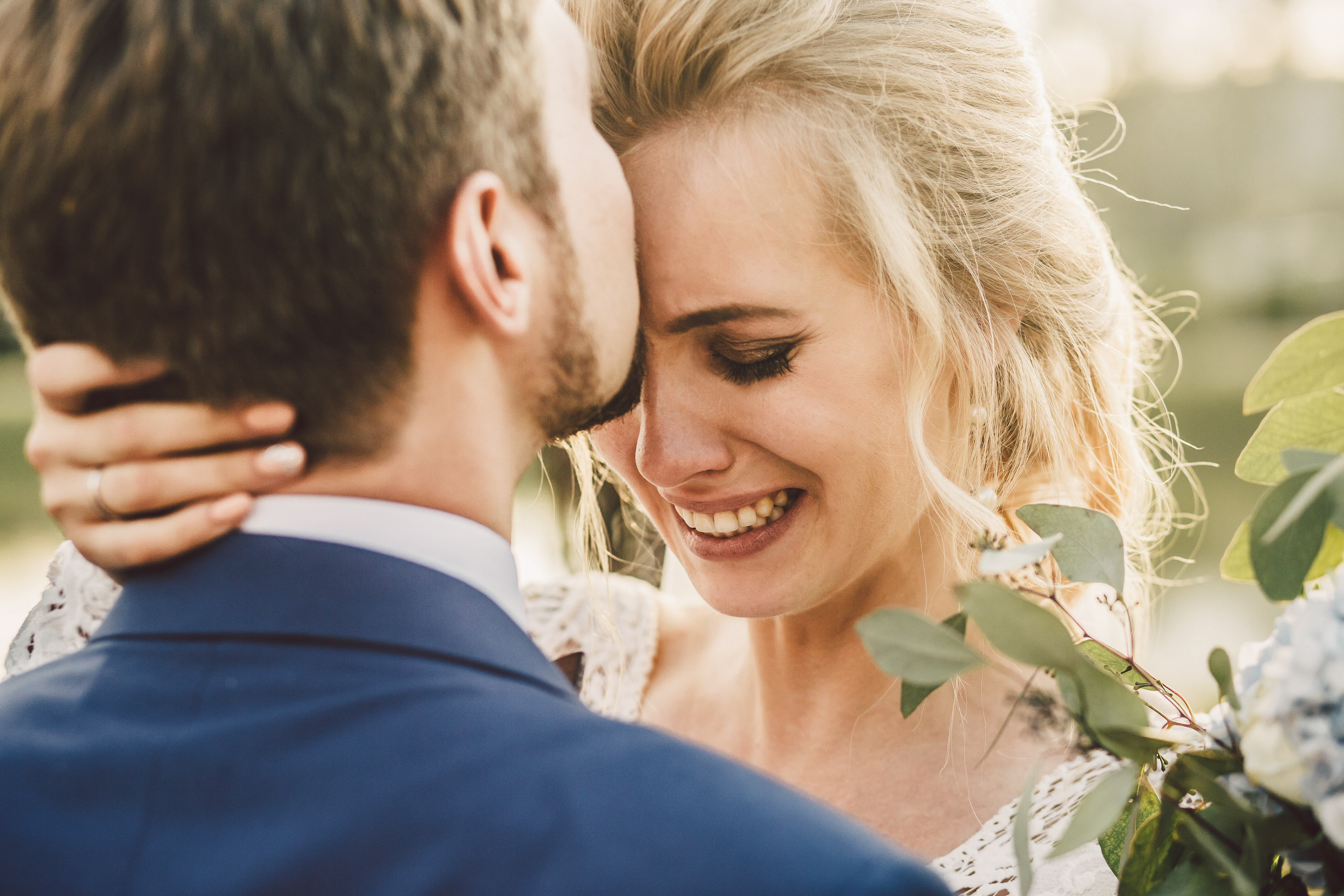 Ein Bräutigam küsst seine Braut auf die Stirn, während sie weint | Quelle: Shutterstock