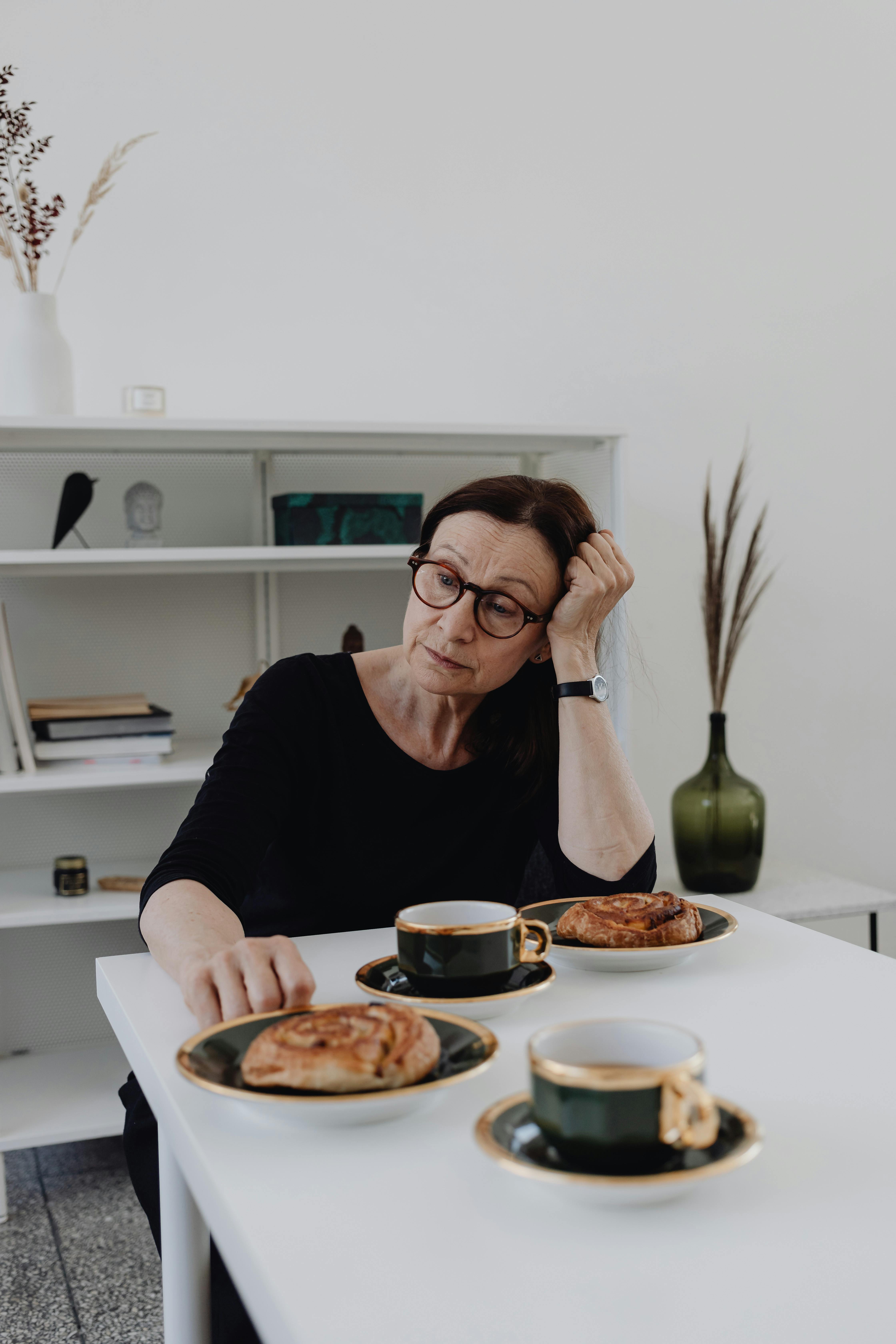 Eine traurige Frau, die an einem Tisch sitzt | Quelle: Pexels