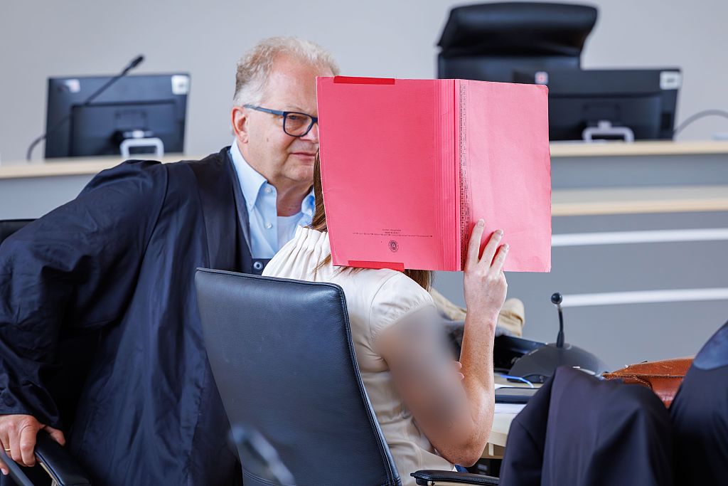 4. Juni 2026, Mecklenburg-Vorpommern, Rostock: Die Angeklagte (r.) verdeckt ihr Gesicht mit einem Hefter und sitzt neben dem Rechtsanwalt Thomas Löcker im Gerichtssaal des Landgerichts vor der Fortsetzung des Mordprozesses im Fall Fabian. | Quelle: Getty Images