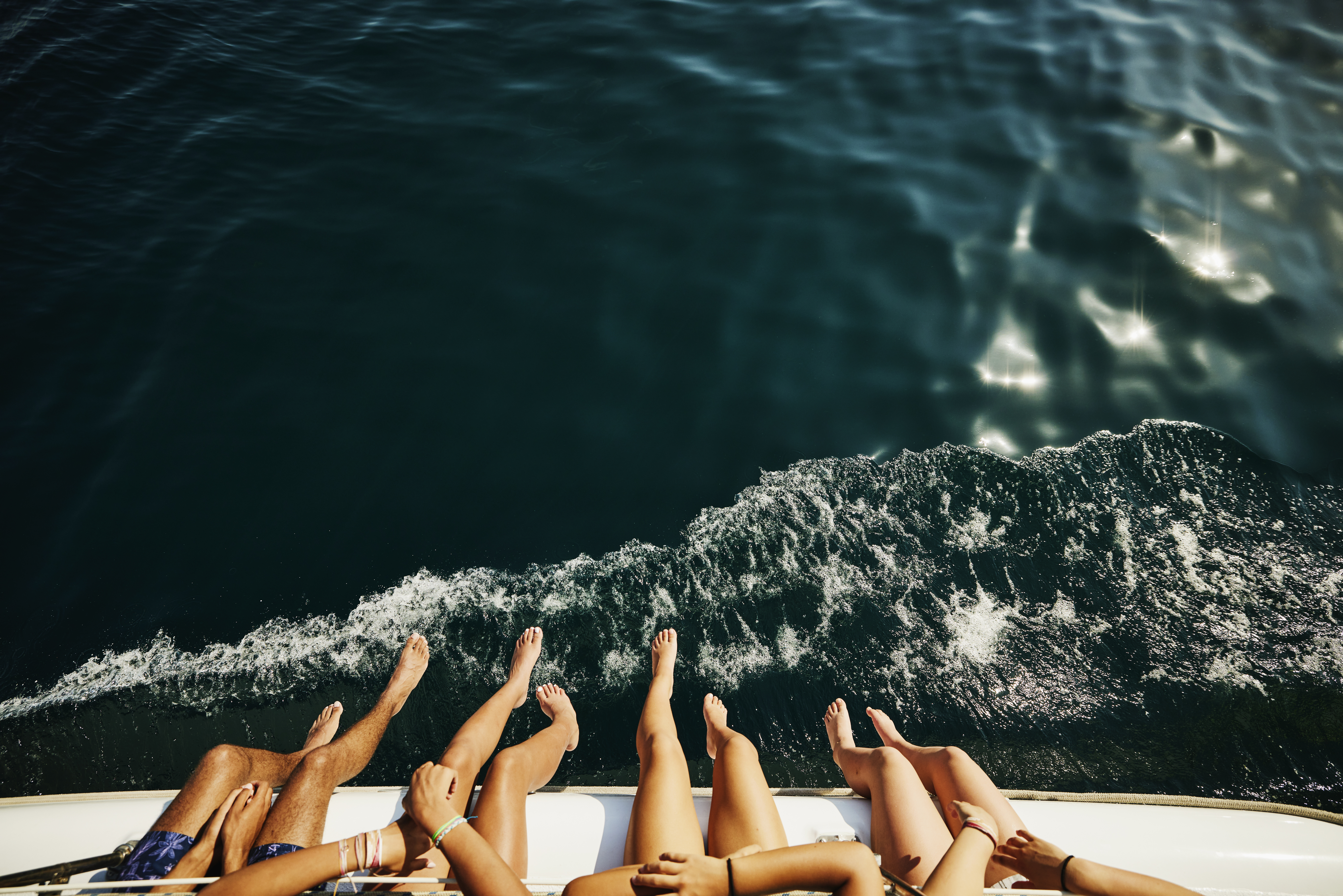 Eine Aufnahme von Menschen, die ihre Beine über den Rand eines Bootes baumeln lassen | Quelle: Getty Images