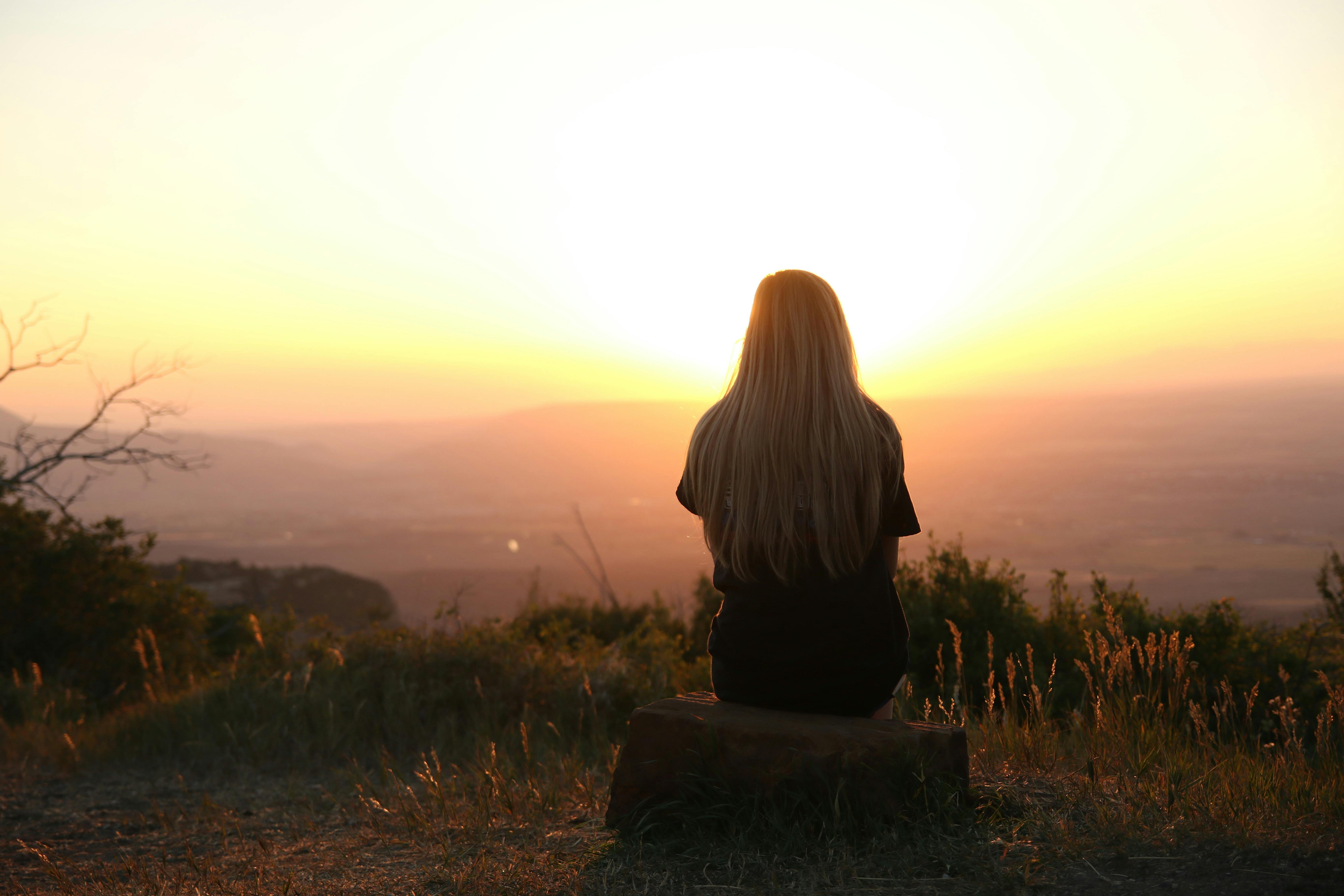 Eine Frau beobachtet den Sonnenuntergang | Quelle: Pexels