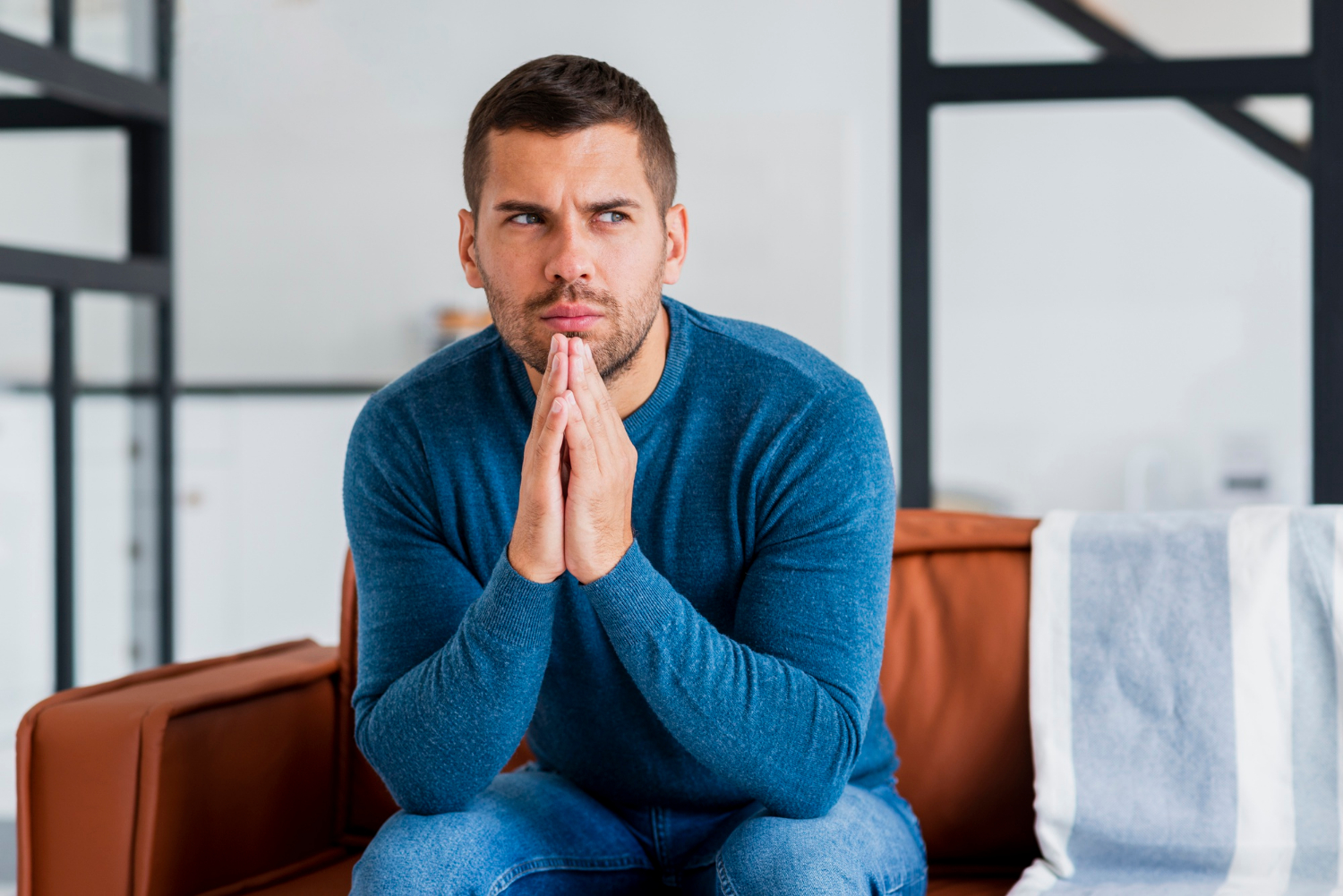 Ein ängstlicher Mann sitzt auf der Couch | Quelle: Freepik