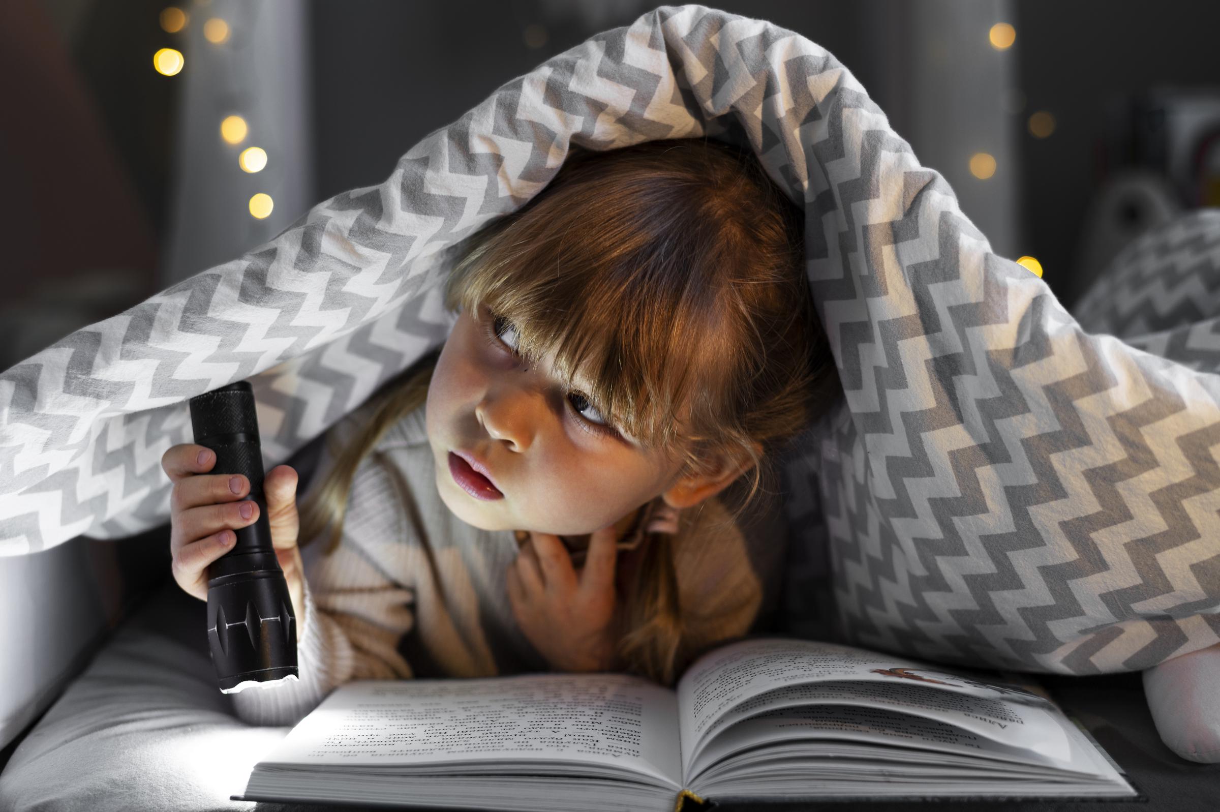 Ein kleines Mädchen hält eine Taschenlampe | Quelle: Freepik