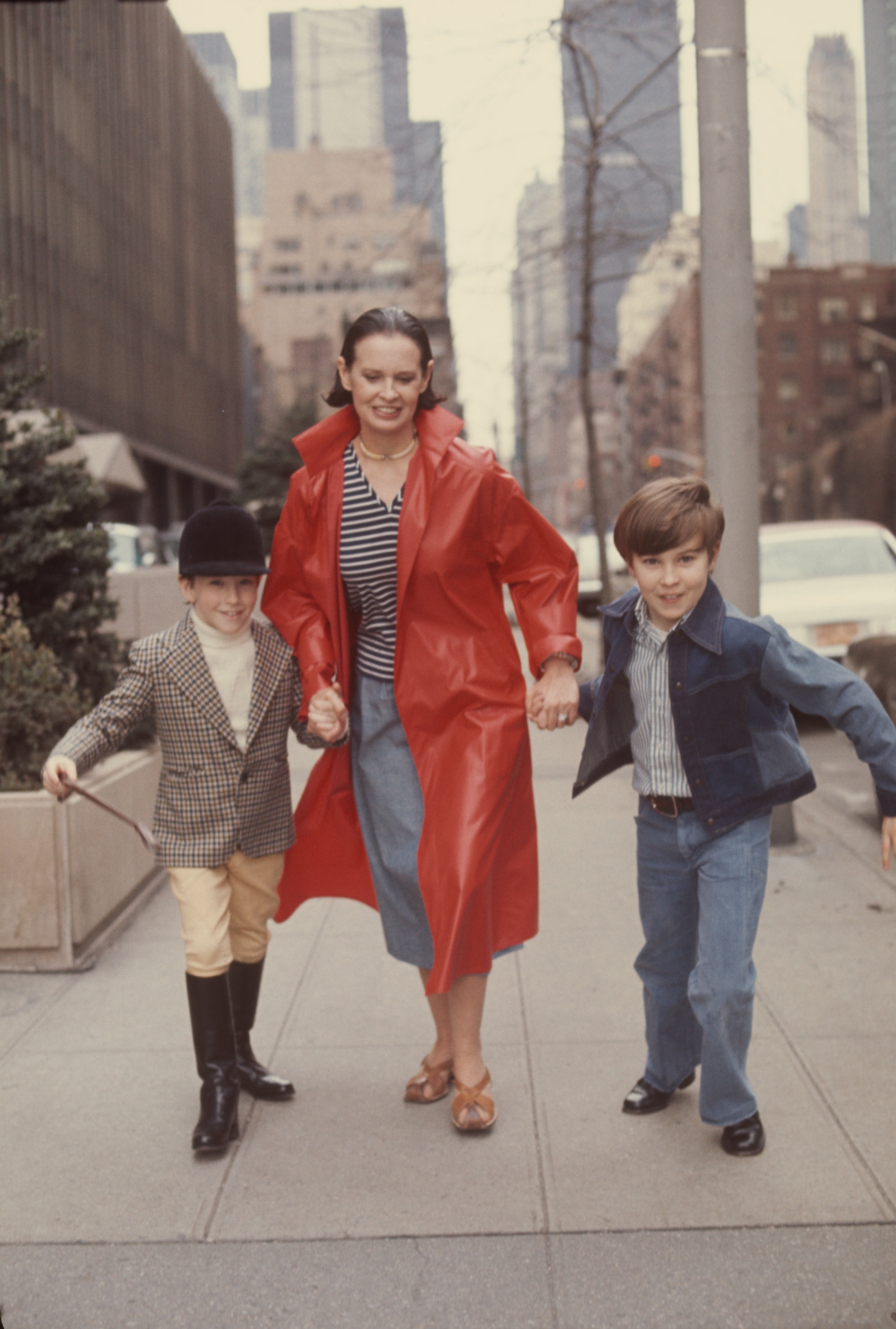 Die gebürtige Schweizerin Gloria Vanderbilt läuft mit ihren beiden Söhnen Anderson Cooper und Carter Vanderbilt Cooper (1965 - 1988) eine Straße entlang, New York, New York, März 1976 | Quelle: Getty Images