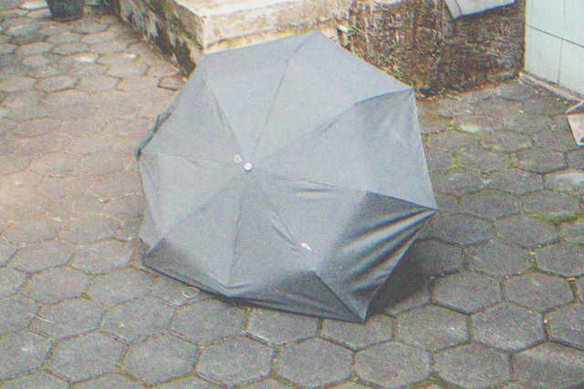 Kaputter alter kleiner schwarzer Regenschirm | Quelle: Shutterstock