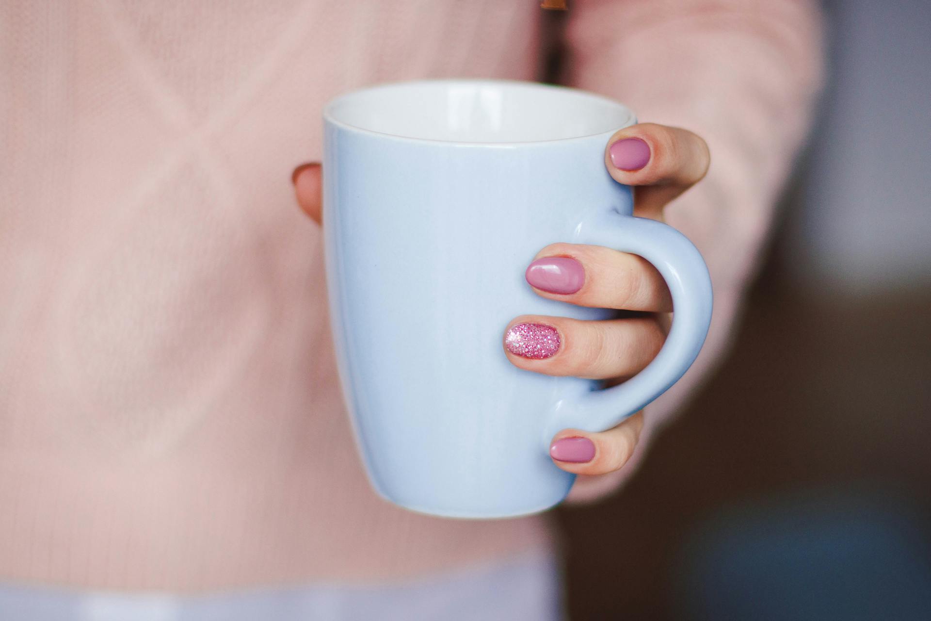 Eine Frau hält einen Becher | Quelle: Midjourney