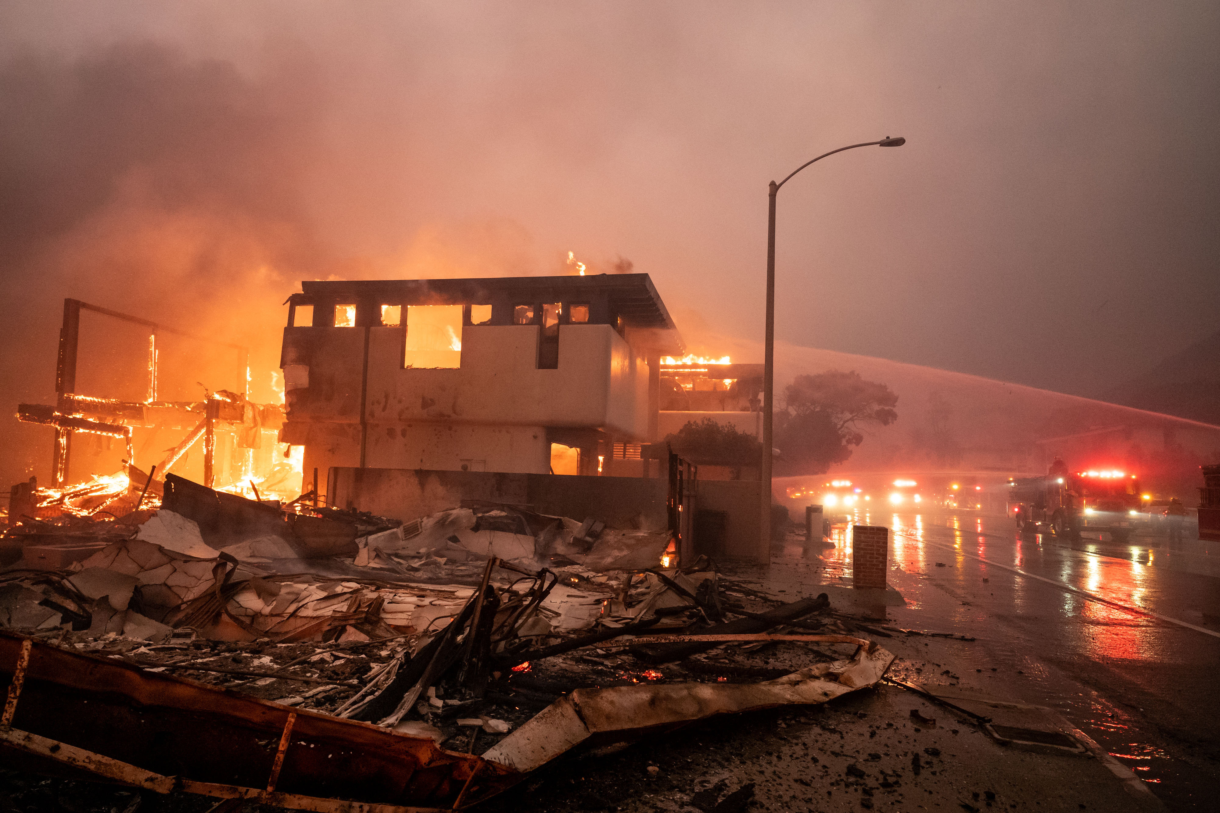 Feuerwehrleute kämpfen weiter gegen Wind und Feuer, während Häuser in Malibu entlang des Pacific Coast Highway in Flammen aufgehen (Palisades Fire, 8. Januar 2025): Getty Images